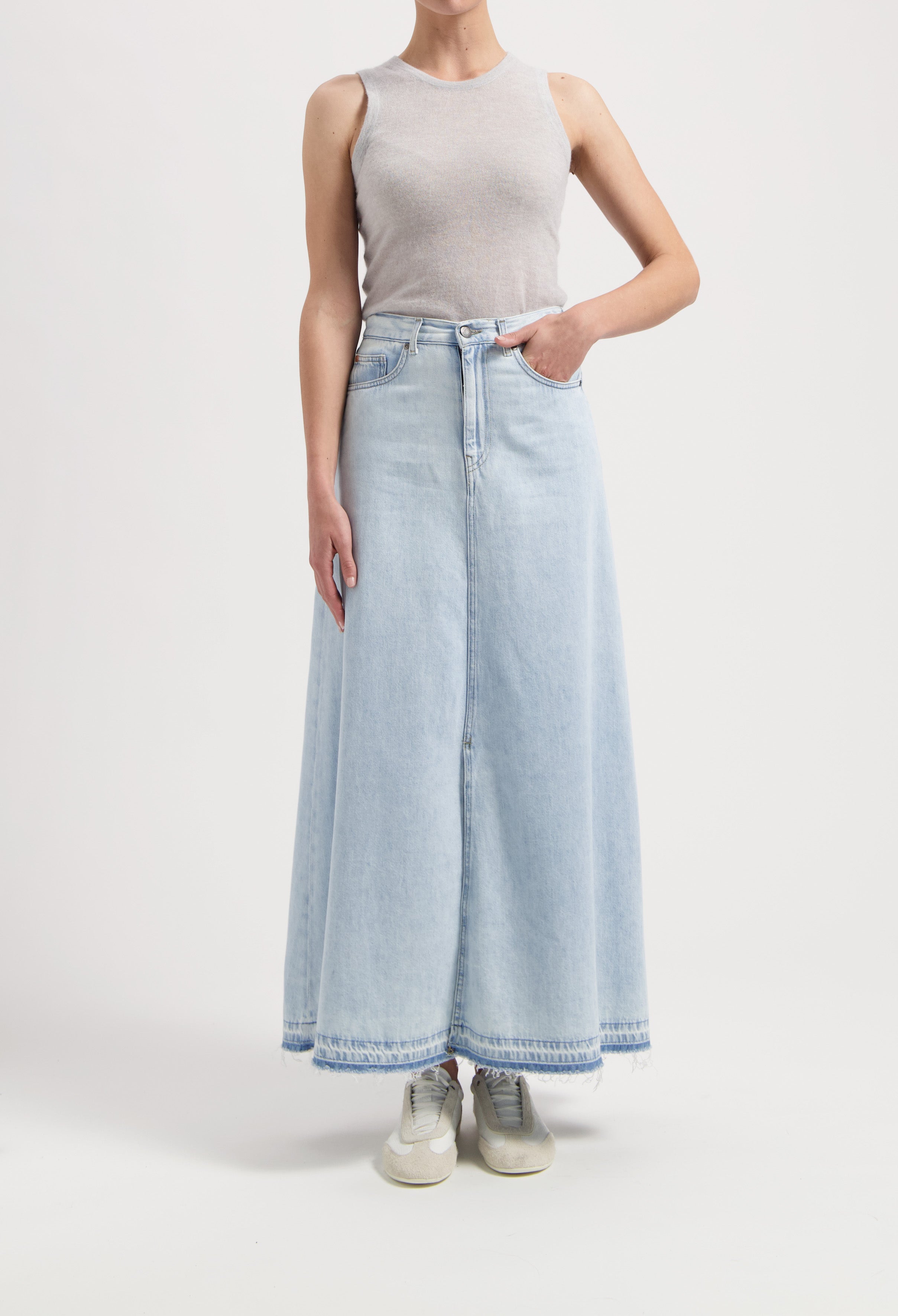 Light blue, high-waisted denim maxi skirt paired with a sleeveless gray top, showcasing casual and stylish wear.