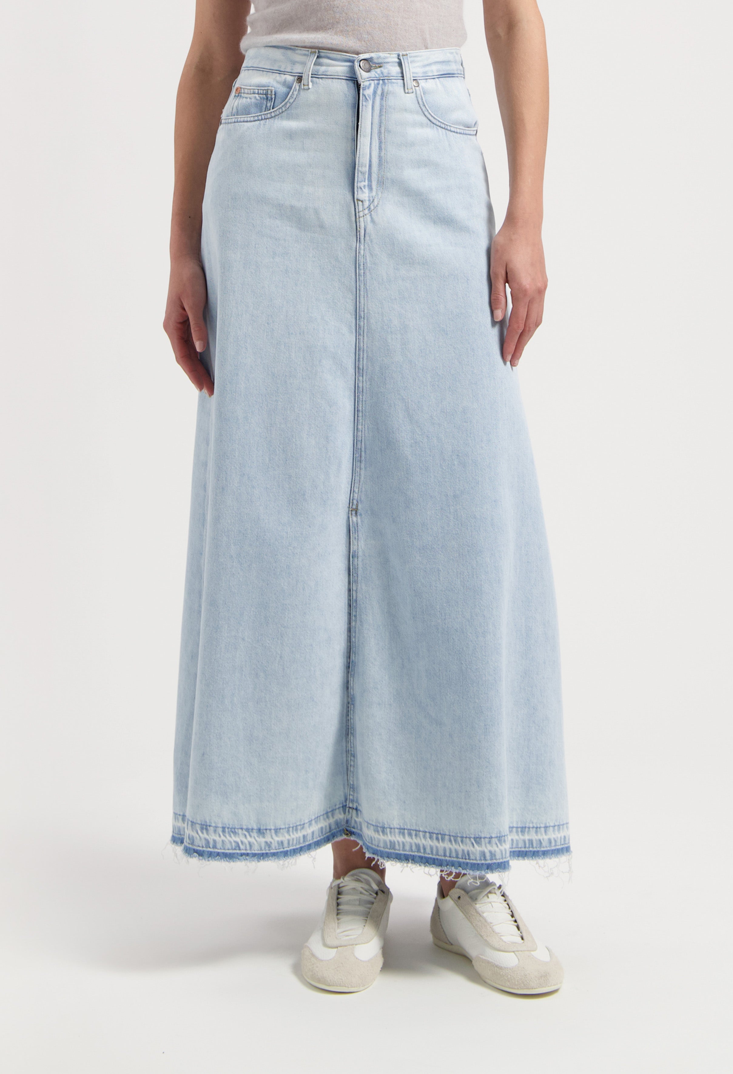 Light blue, full-length denim skirt with frayed hem, paired with white sneakers and a gray sleeveless top on a white background.