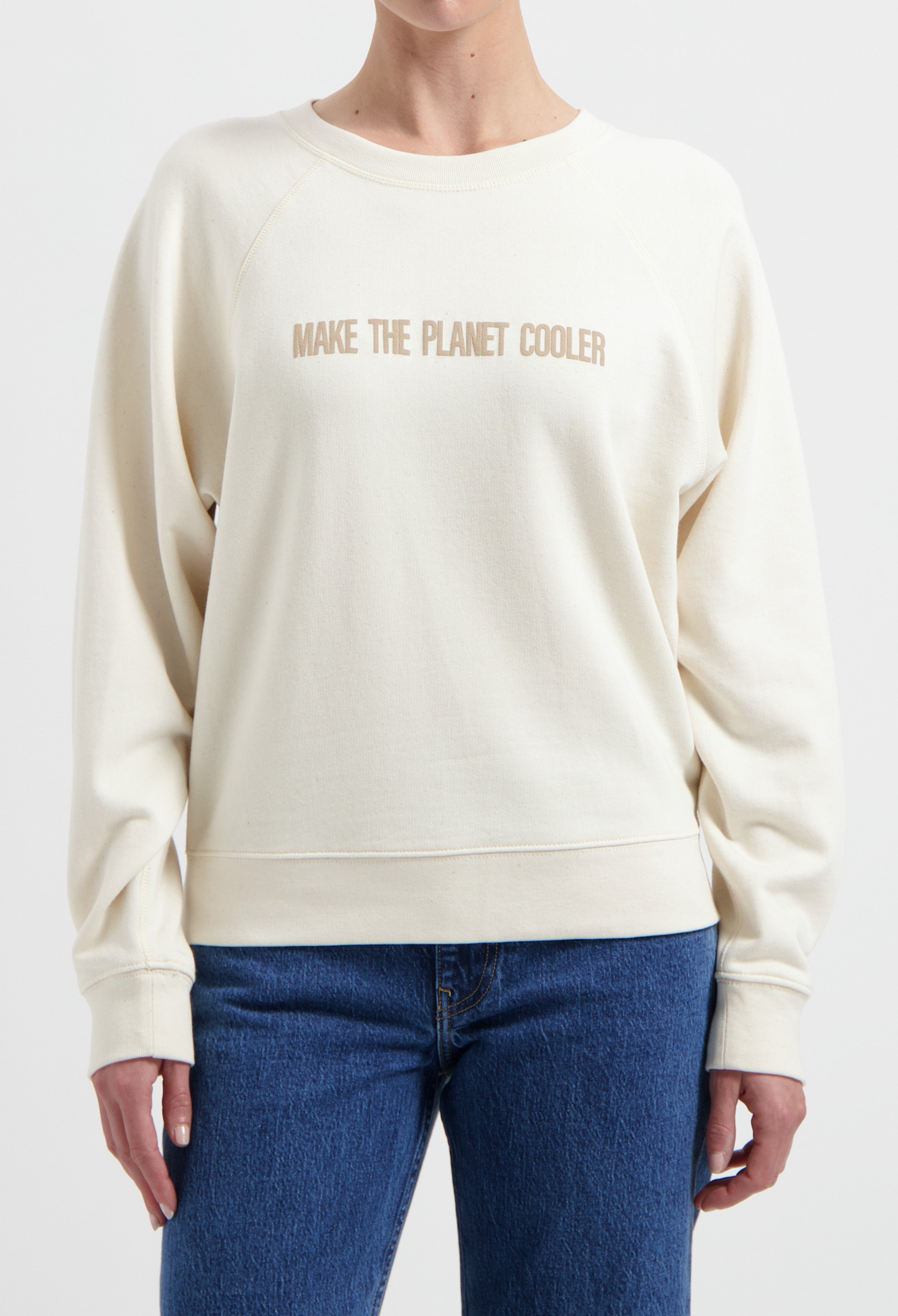 Ivory crew neck sweatshirt with a "Make the Planet Cooler" slogan, paired with classic blue denim jeans.