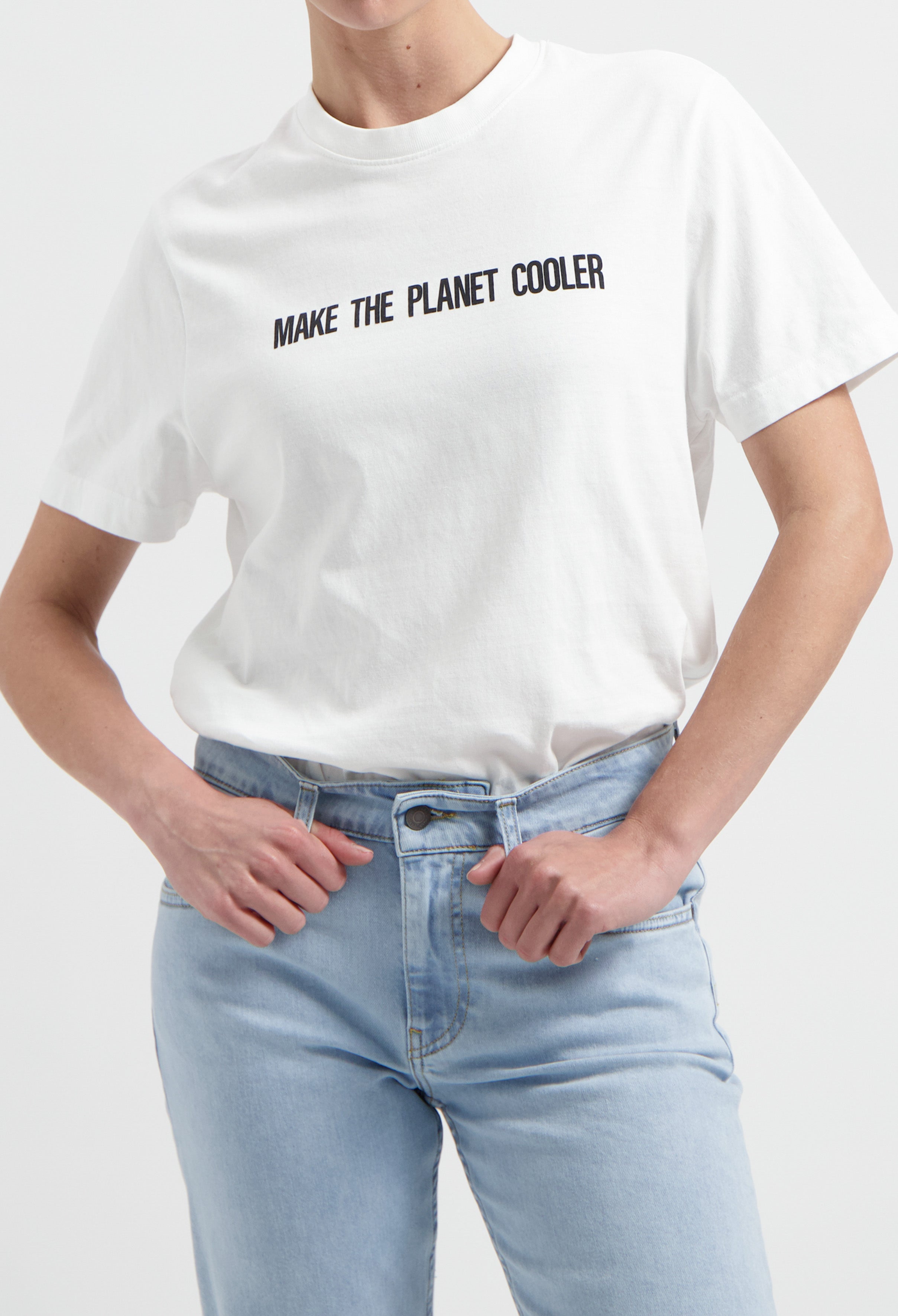 White eco-friendly T-shirt with "Make the Planet Cooler" slogan, paired with faded blue high-waisted jeans.