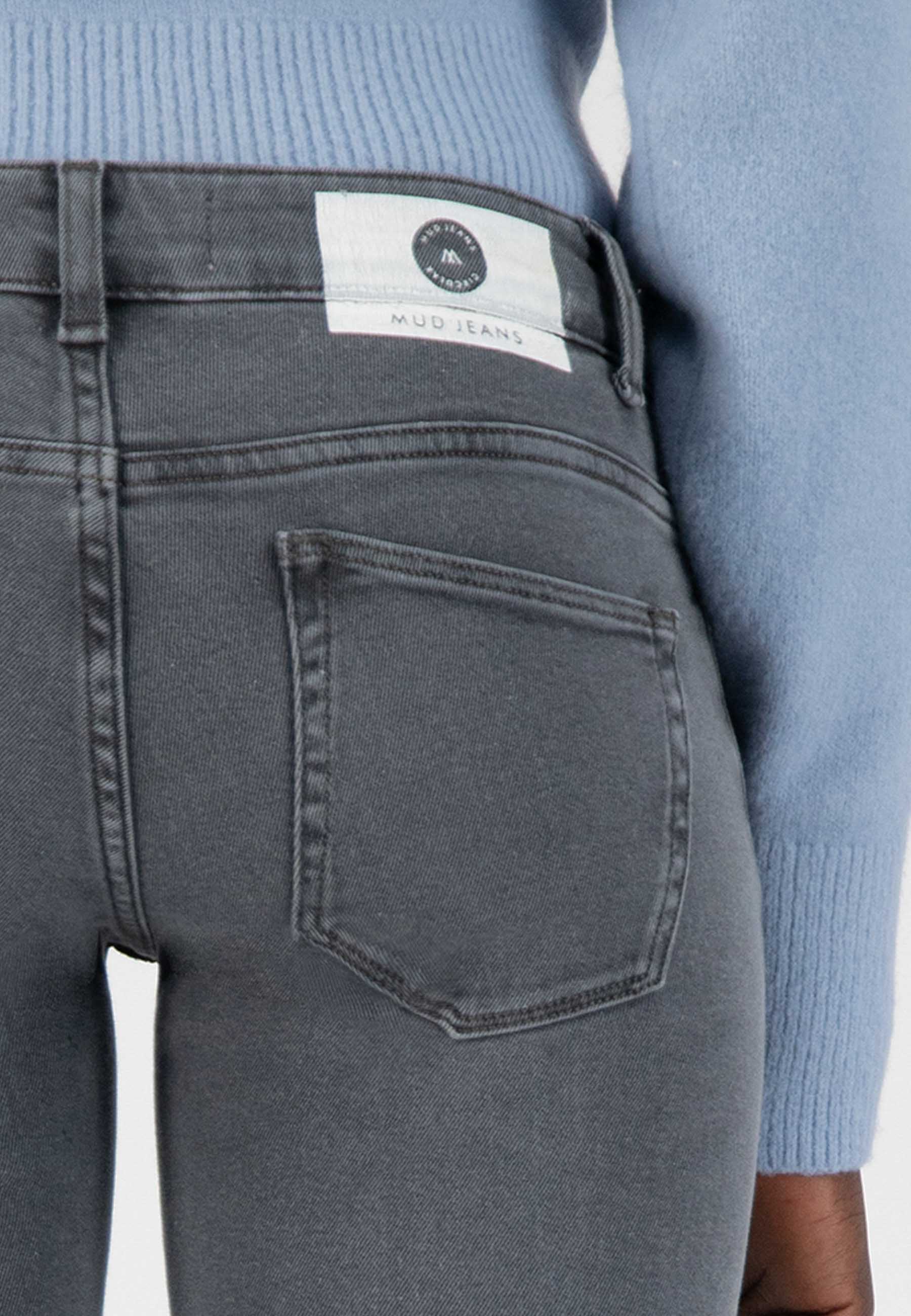 Dark gray slim-fit MUD Jeans crafted from organic cotton, featuring a back pocket detail and paired with a light blue top.