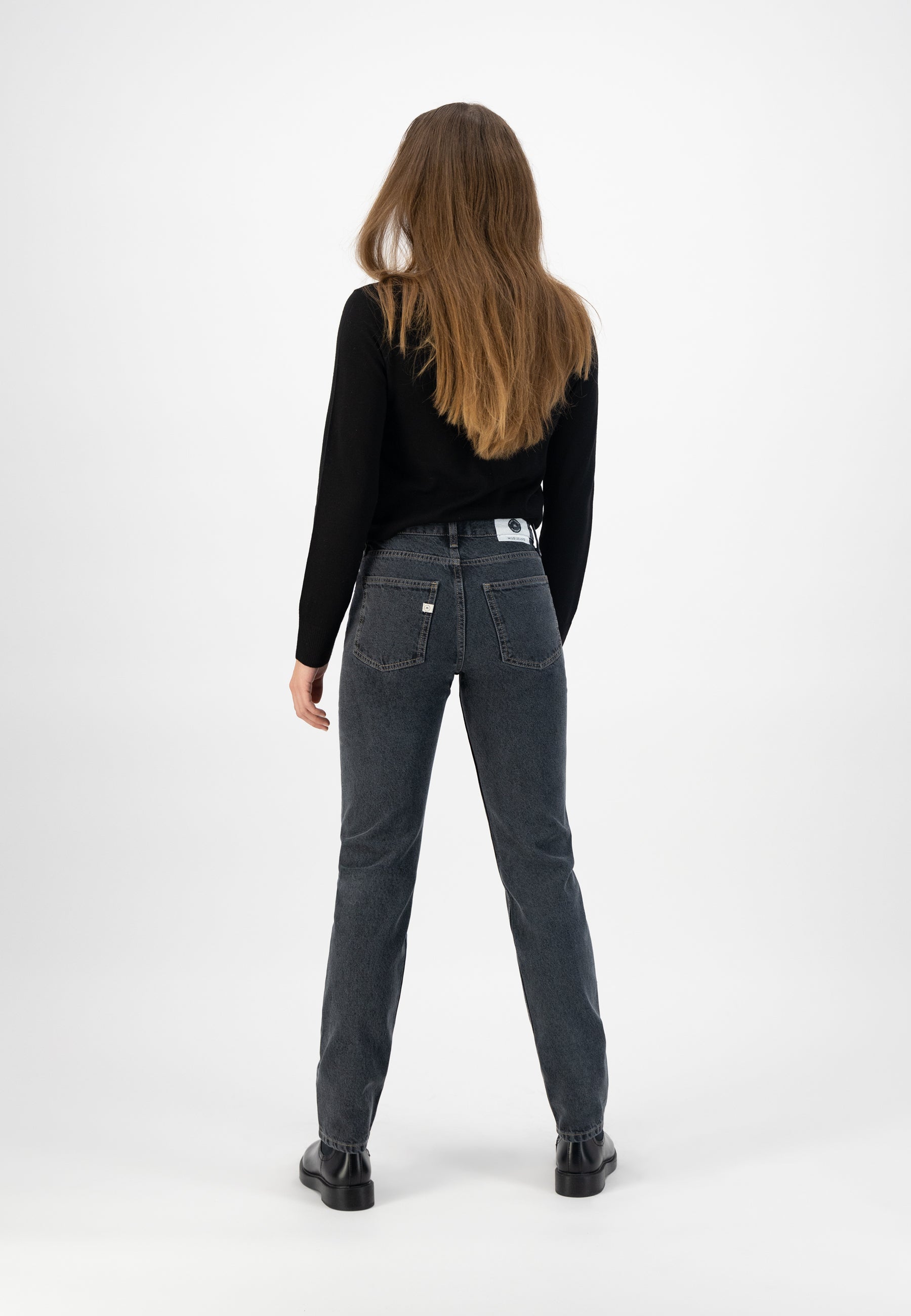 High-waisted dark gray denim jeans paired with a black long-sleeve sweater, showcasing a casual back view style.