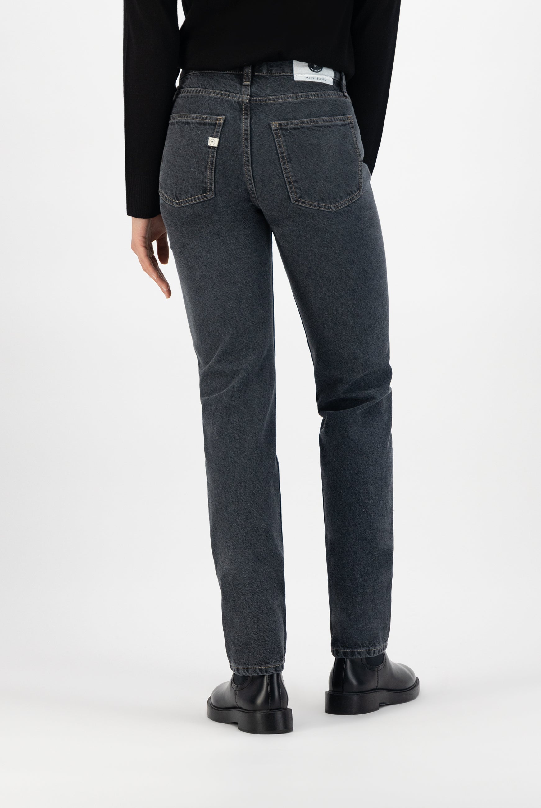 Casual mid-rise gray denim jeans in a straight-leg fit, paired with a black top and stylish black leather shoes.