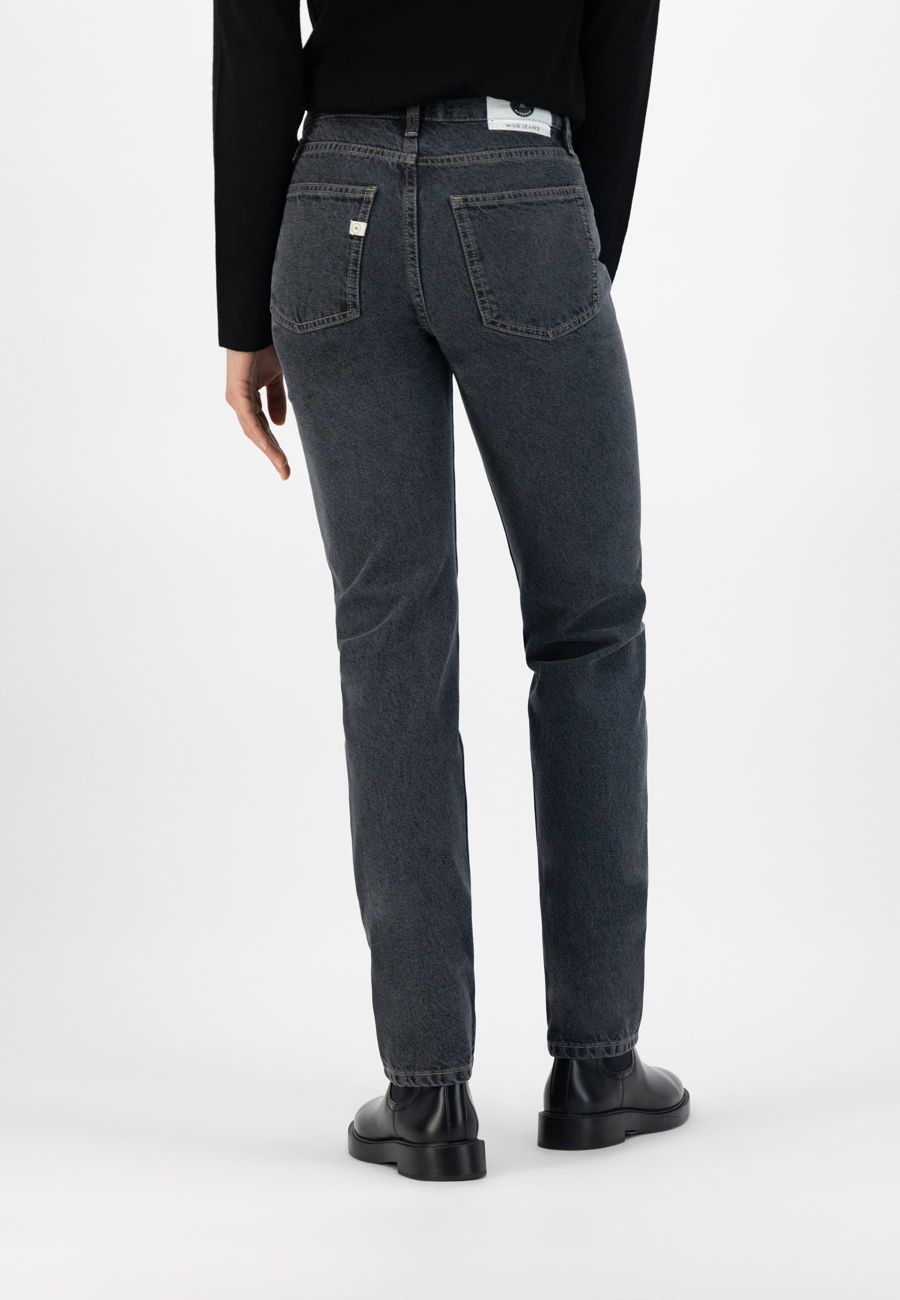 Casual mid-rise gray denim jeans in a straight-leg fit, paired with a black top and stylish black leather shoes.