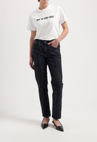 Sustainable MUD Jeans in light blue, organic cotton, flare fit, paired with a white ethical cotton tee and white sneakers.