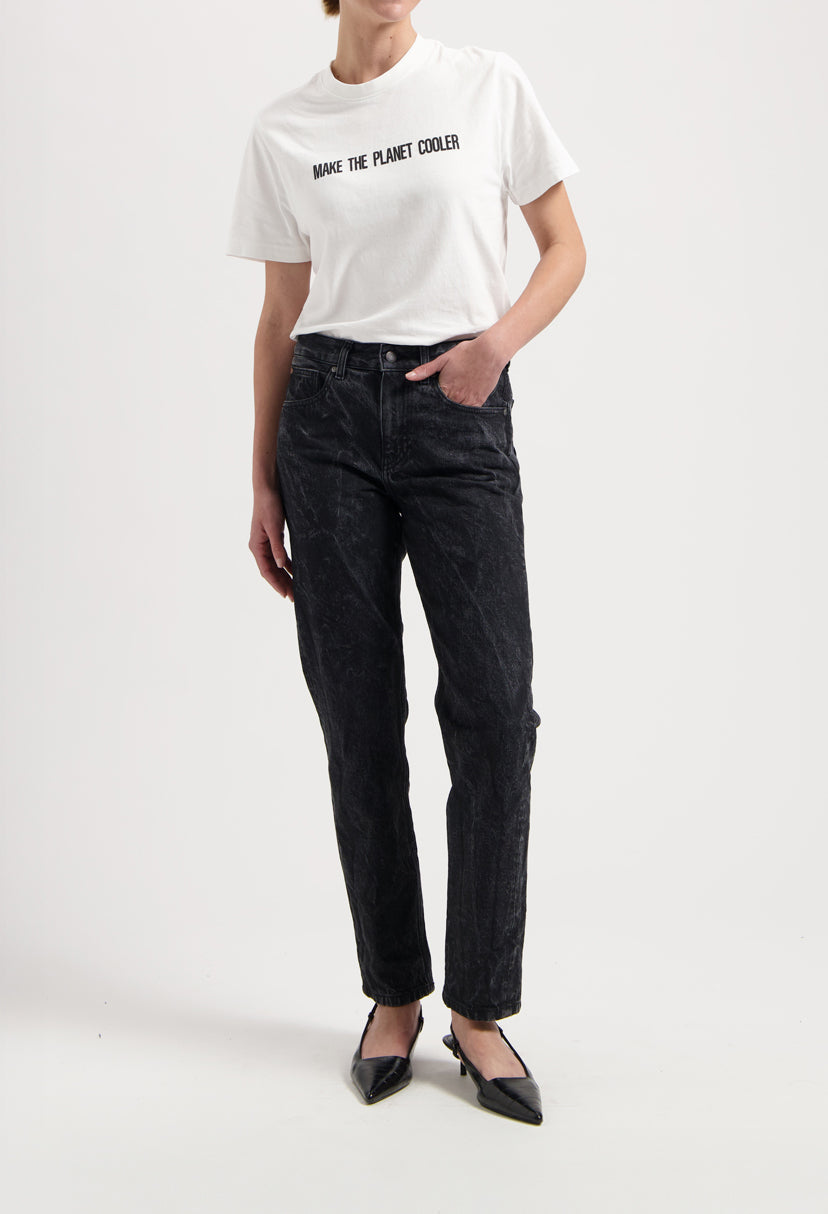 Sustainable MUD Jeans in light blue, organic cotton, flare fit, paired with a white ethical cotton tee and white sneakers.