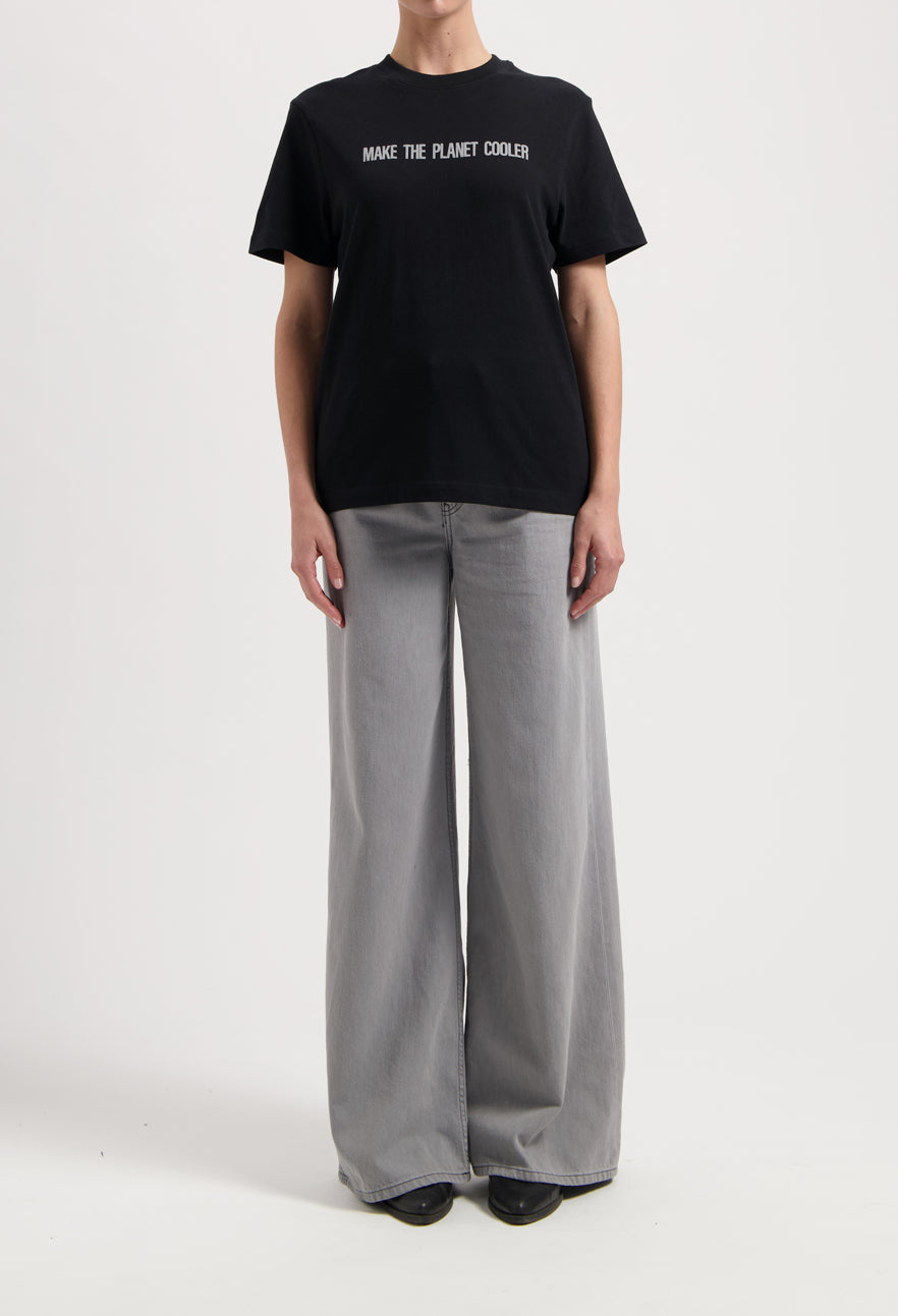 Sustainable MUD Jeans in dark brown, crafted with ethical materials, shown in a slim fit, paired with a casual white tee.