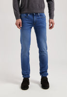 Sustainable MUD Jeans in dark blue denim, crafted ethically from organic cotton, paired with a casual gray t-shirt.