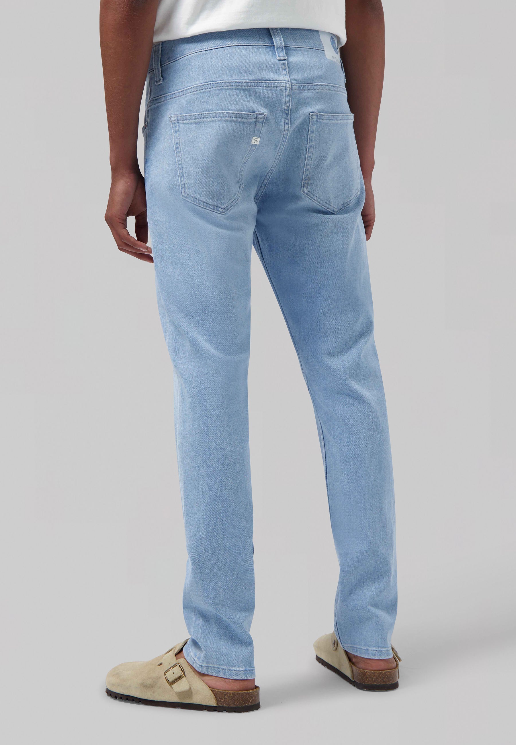 Sustainable MUD Jeans in blue denim, classic straight fit, eco-friendly and made from organic cotton, paired with white shirt.
