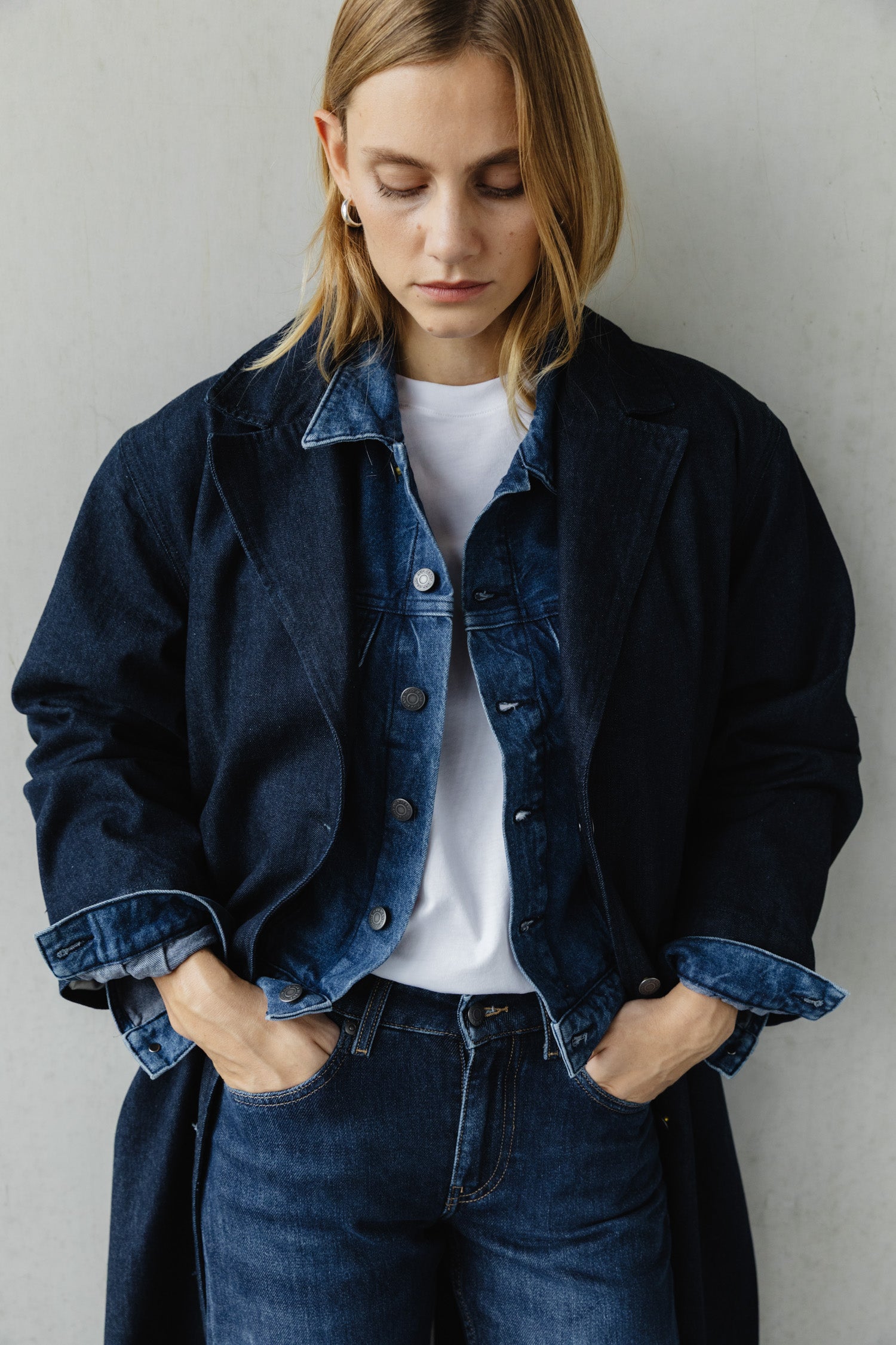 Casual outfit with a dark blue denim jacket and jeans, worn over a white T-shirt, showcasing a relaxed style.