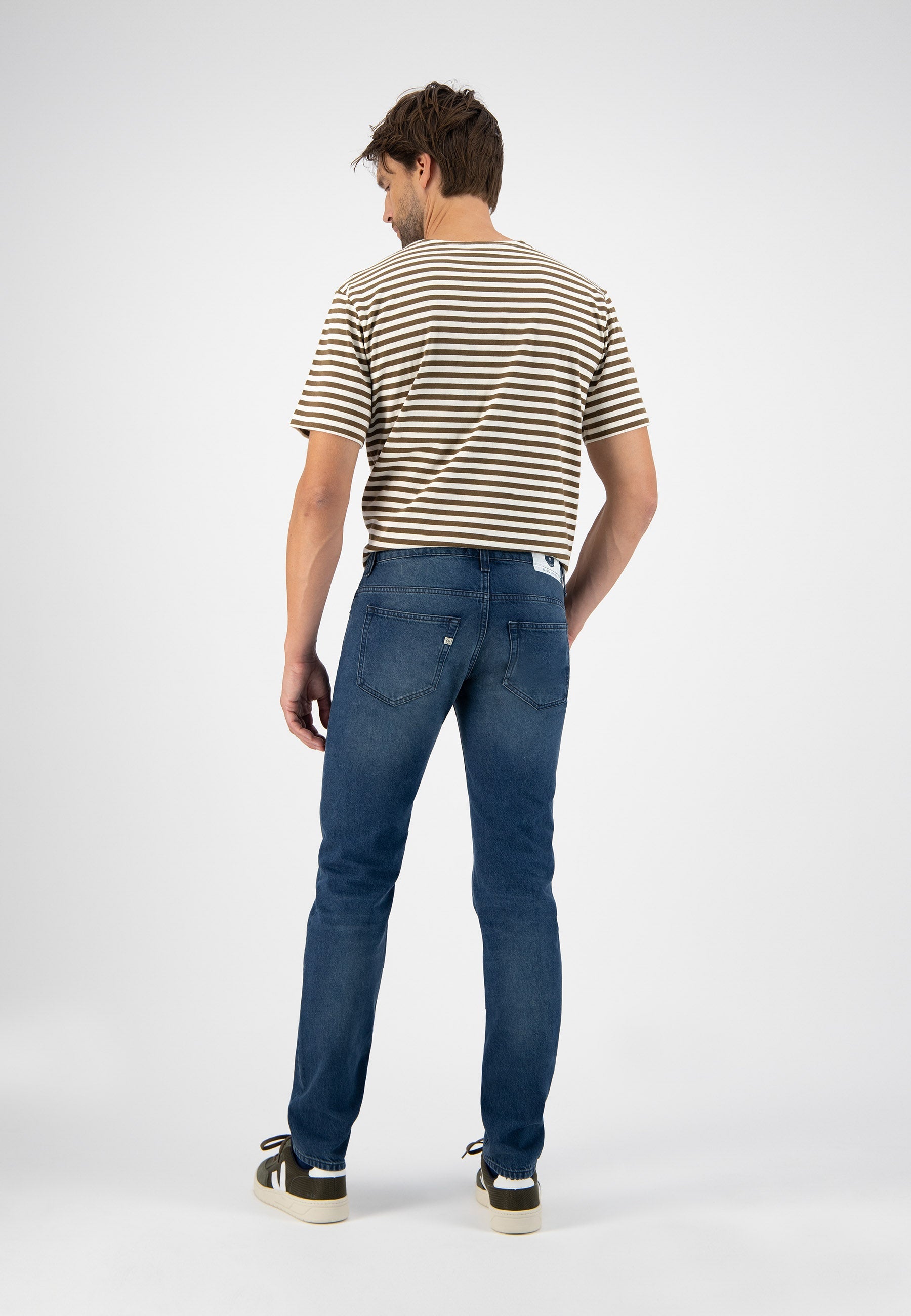 Sustainable MUD Jeans in dark blue denim, showcasing ethical design with classic fit, paired with a white t-shirt.