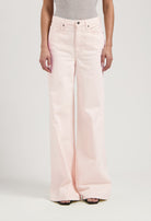 High-waisted, wide-leg light pink denim jeans paired with a gray sleeveless top, showcasing a minimalist fashion style.