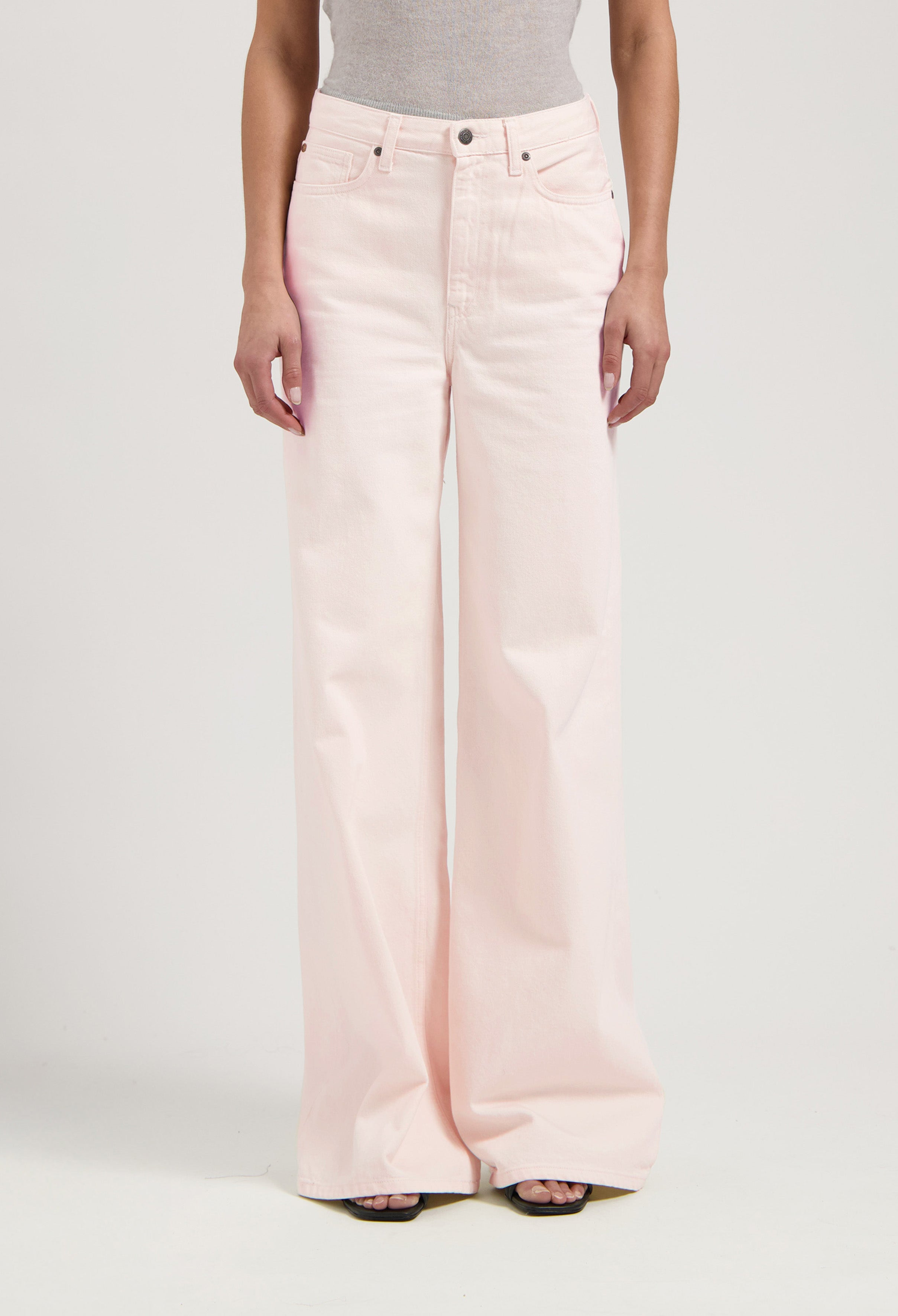 High-waisted, wide-leg light pink denim jeans paired with a gray sleeveless top, showcasing a minimalist fashion style.