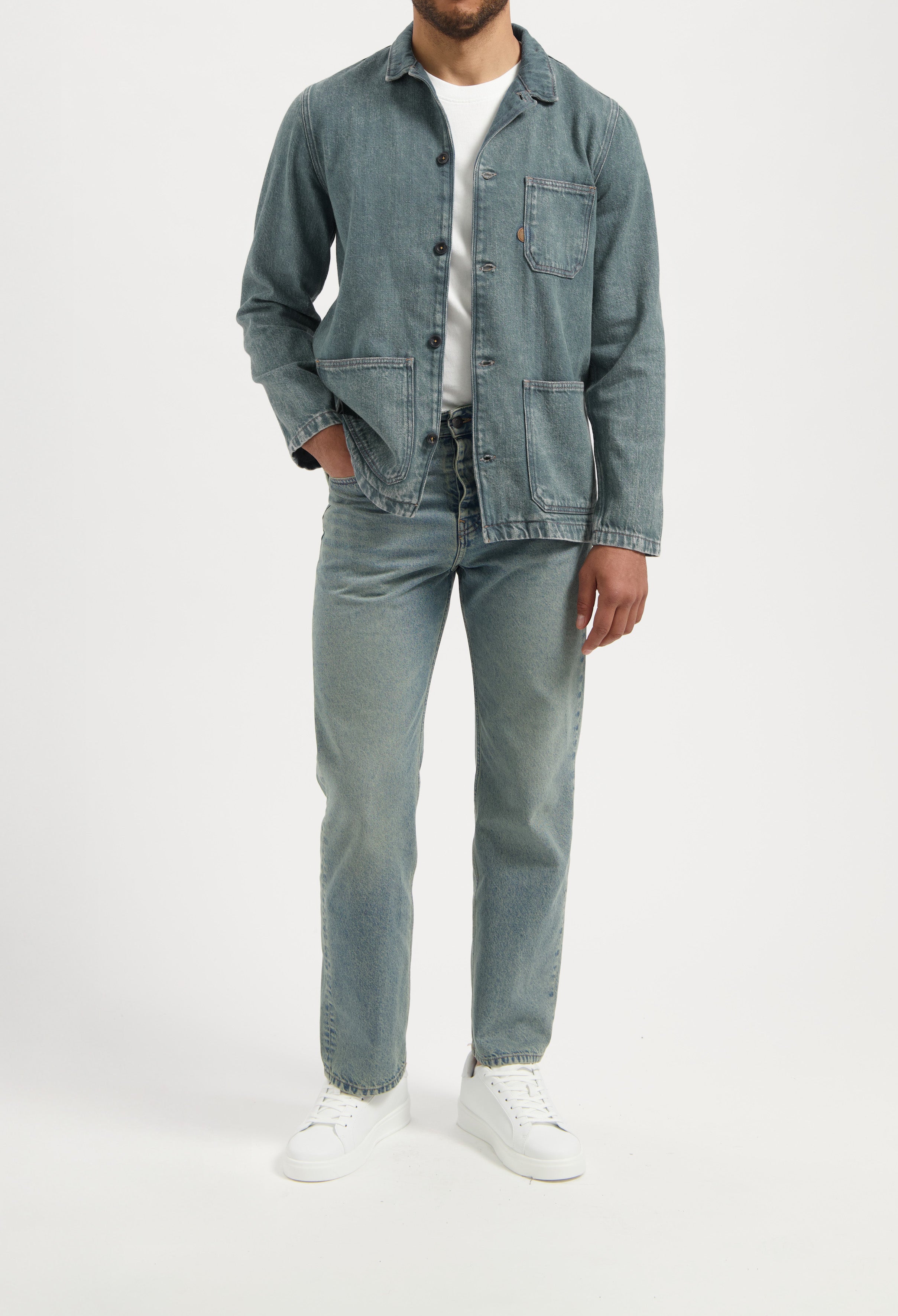 Sustainable MUD Jeans in light blue denim, ethical fashion choice, paired with a white t-shirt, back view.