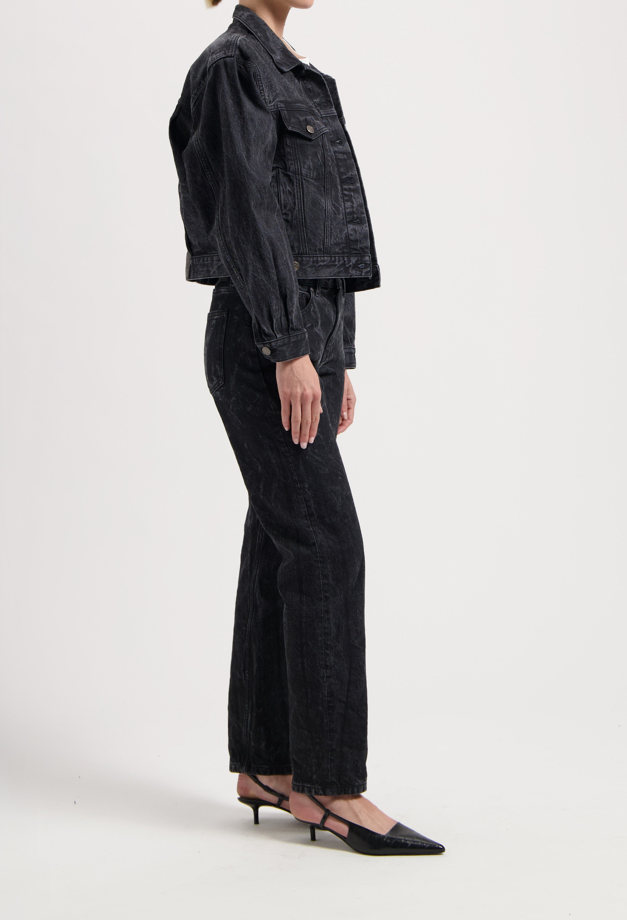 Dark wash denim jacket and wide-leg jeans ensemble paired with black pointed-toe heels, showcasing a chic casual outfit.