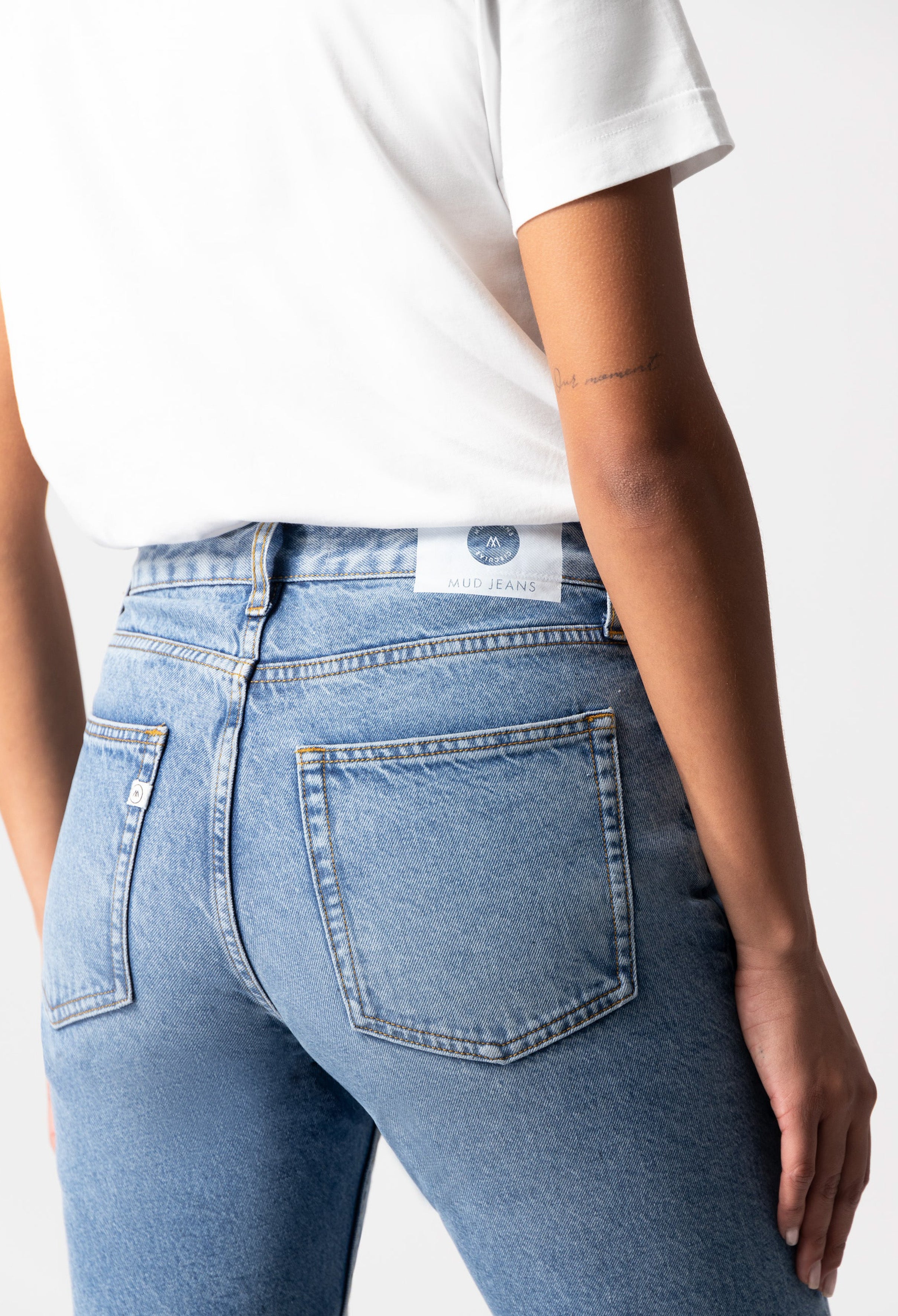 Light blue MUD Jeans in a classic fit, highlighting eco-friendly denim fabric, paired with a simple white T-shirt.