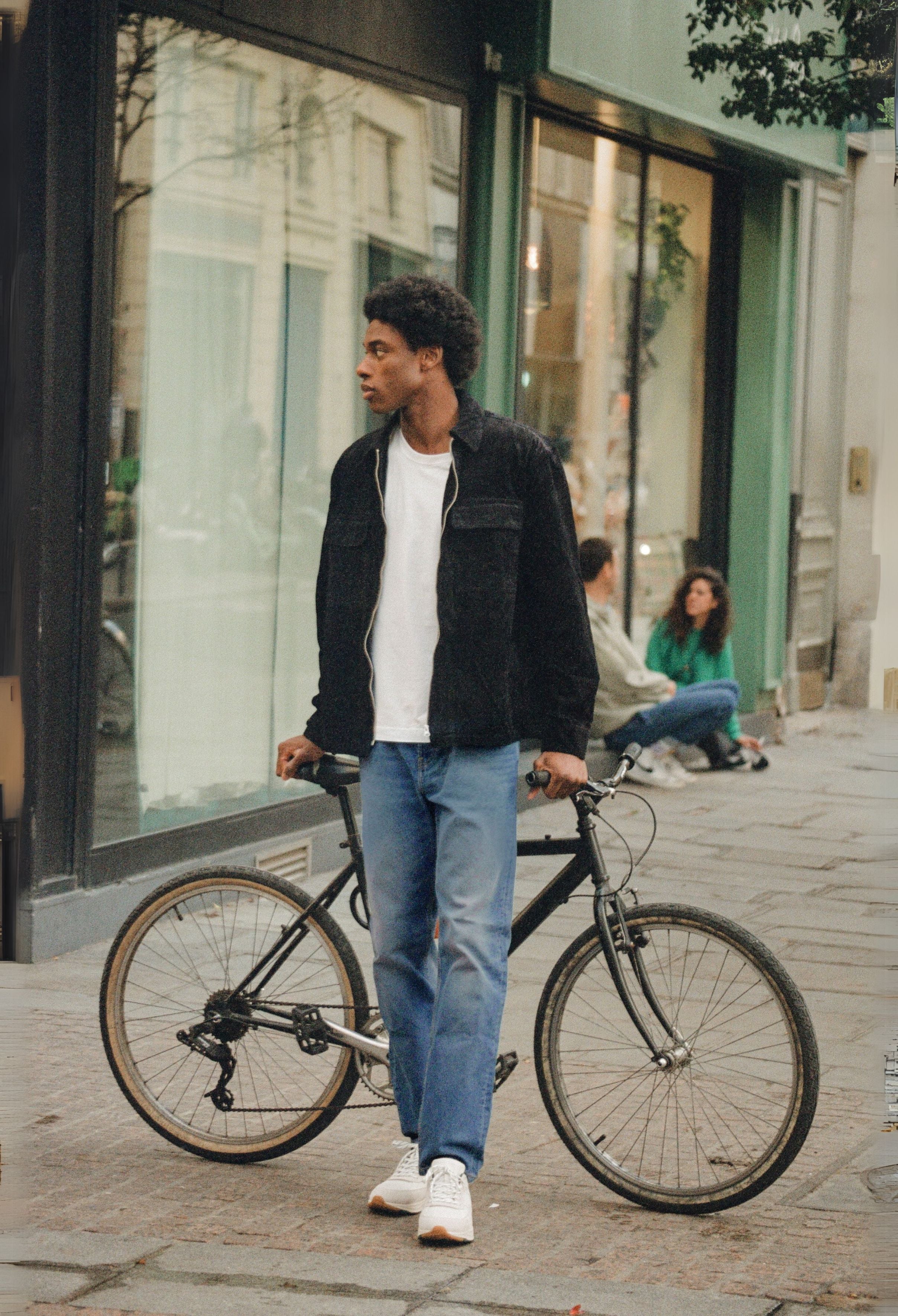 Sustainable MUD Jeans crafted from organic cotton, featuring deep blue denim, paired with a soft gray sweater.