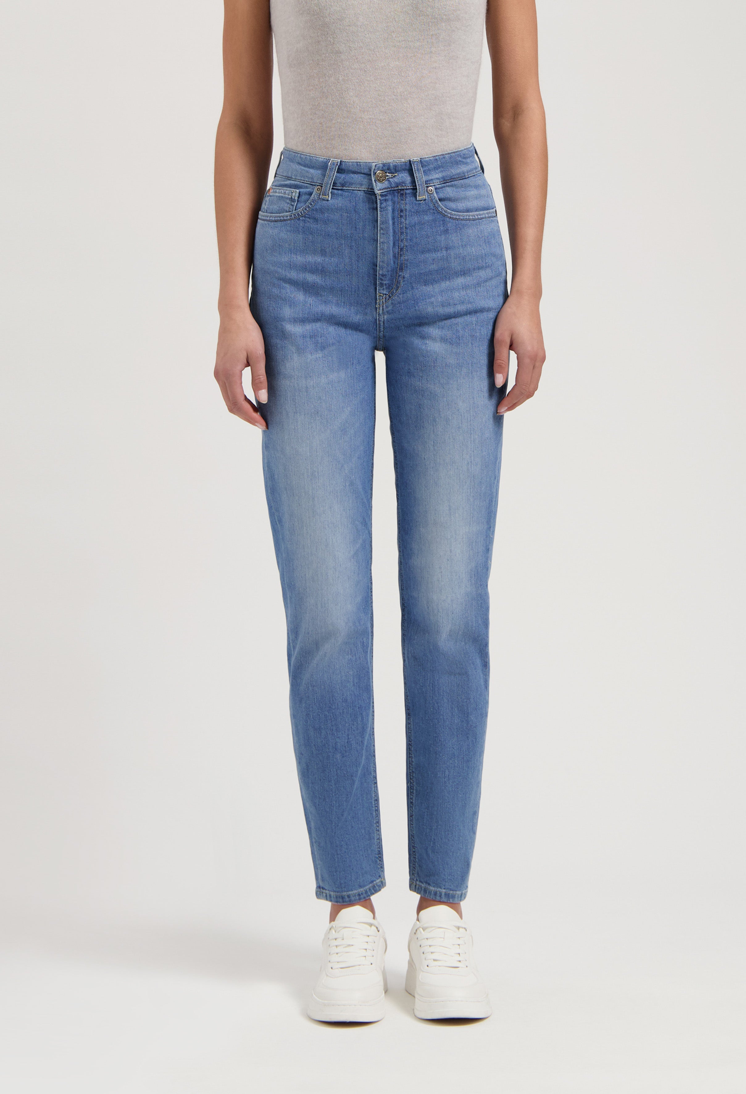 Casual blue jeans with high waist fit paired with a light gray sleeveless top and white sneakers for a relaxed look.