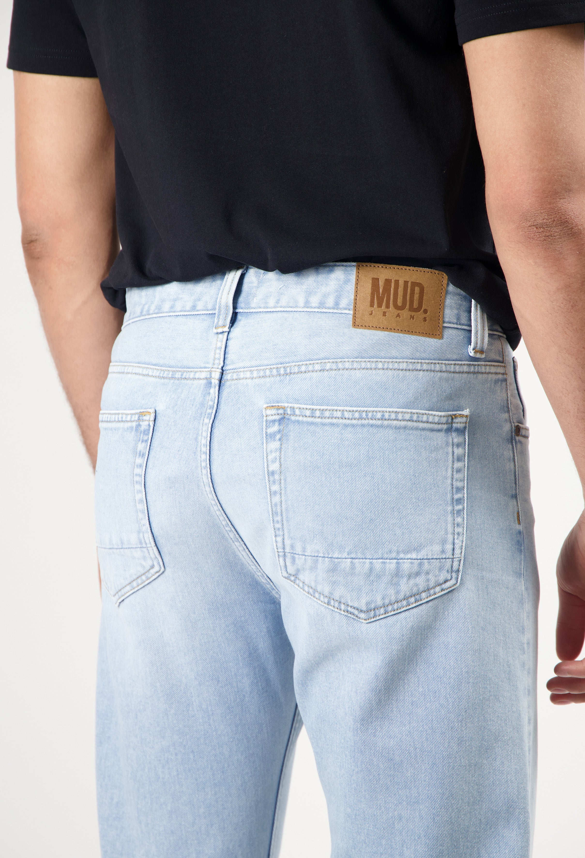 Sustainable MUD Jeans in dark blue denim, featuring classic stitching and ethical design, view of back pocket detail.