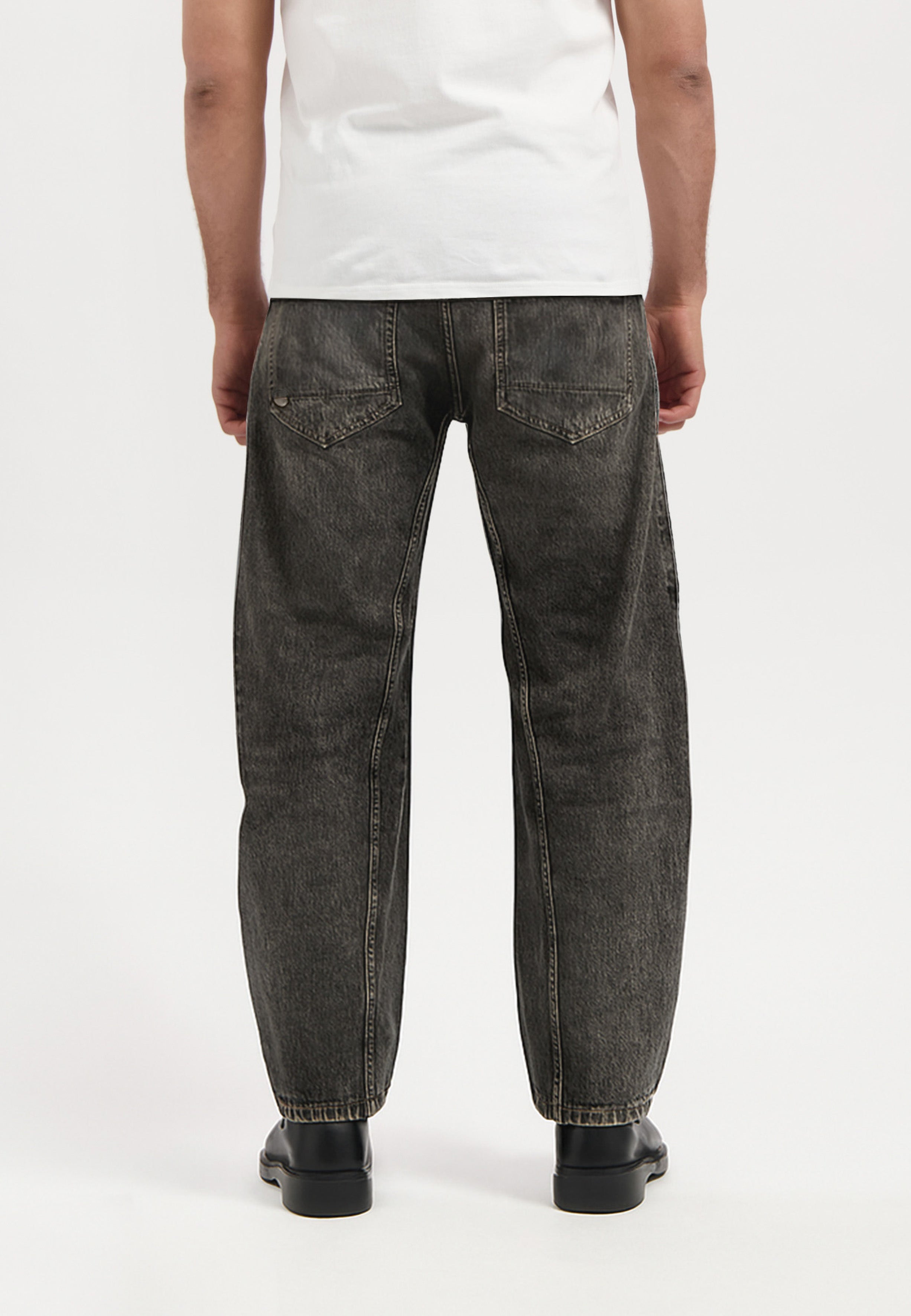 Sustainable MUD Jeans in dark blue denim, showcasing eco-friendly design and slim fit, paired with casual white sneakers.