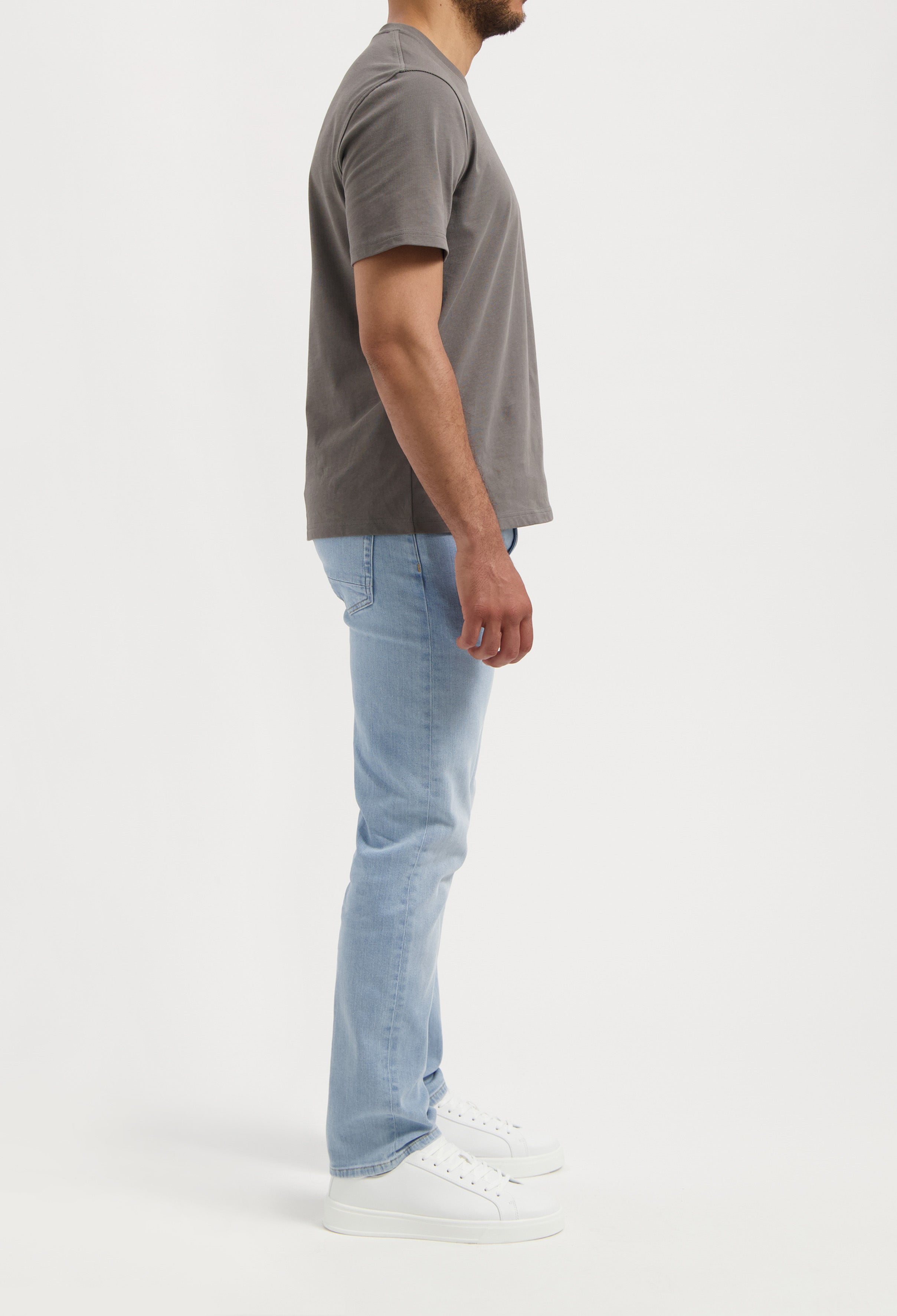 Sustainable MUD Jeans light blue denim shorts made from ethical materials, shown with a green t-shirt, highlighting eco-friendly fashion.