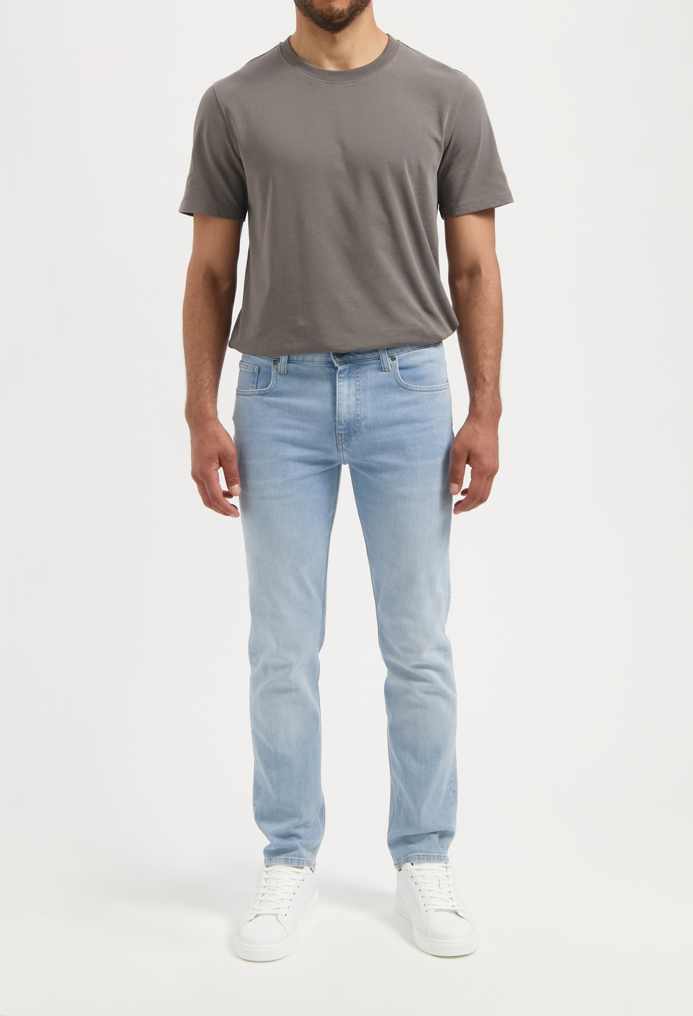 Sustainable MUD Jeans denim shorts in light blue, ethically made from organic cotton, paired with a casual green tee.