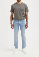 Sustainable MUD Jeans denim shorts in light blue, ethically made from organic cotton, paired with a casual green tee.