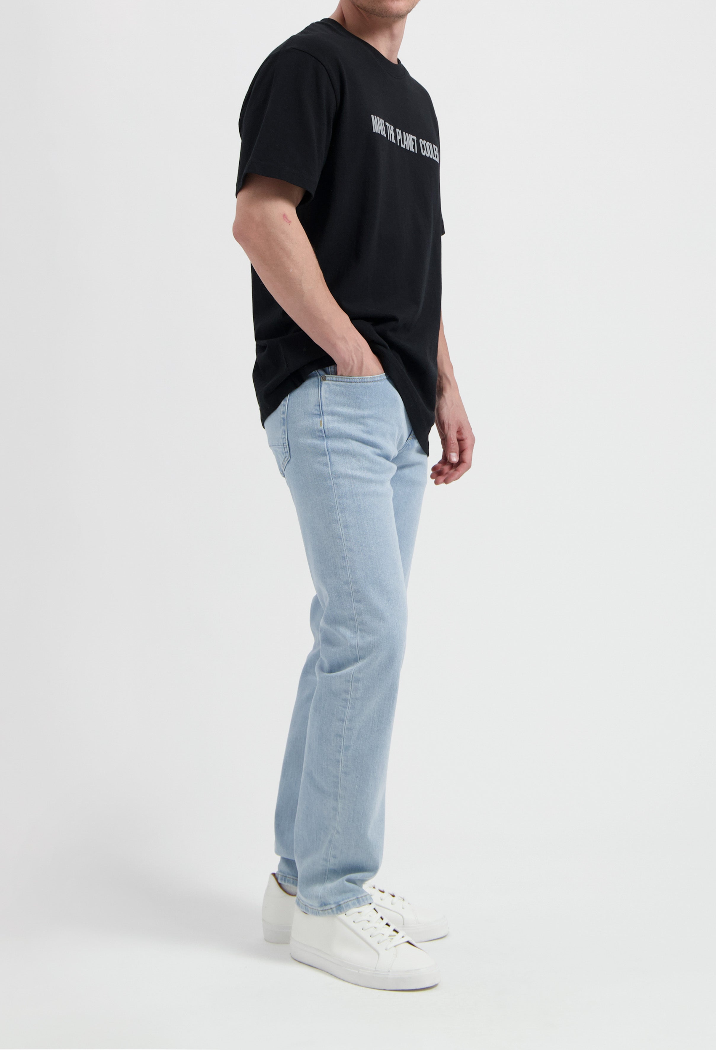 Sustainable MUD Jeans in classic blue denim crafted from organic cotton, paired with a casual white T-shirt.