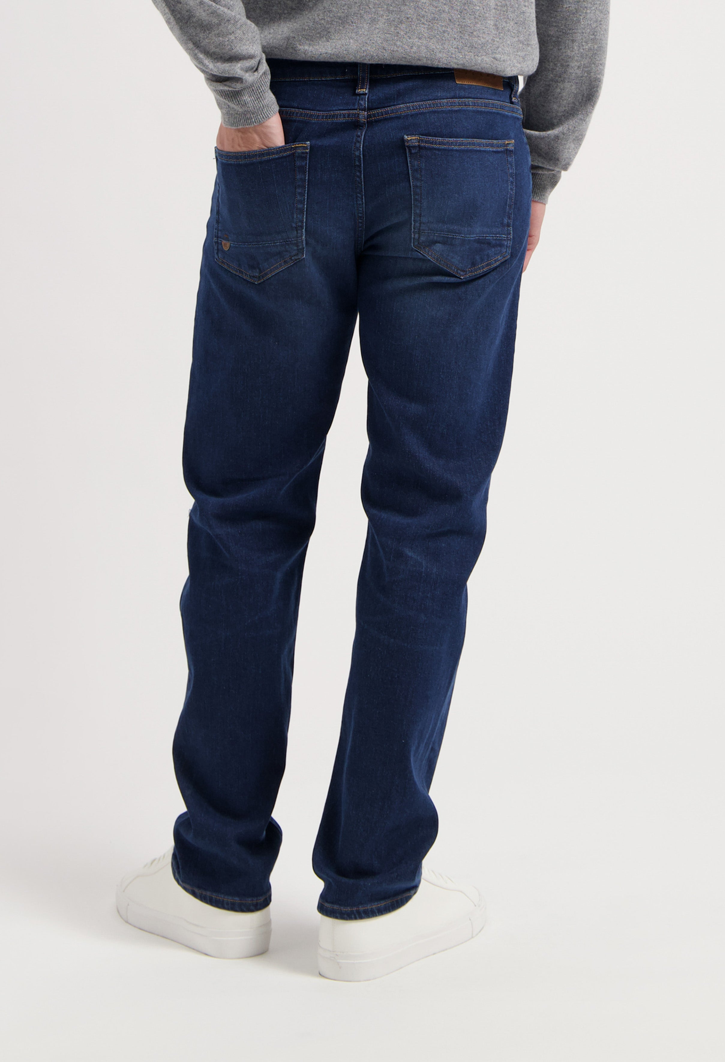 Sustainable MUD Jeans jacket and jeans in light blue denim, crafted from organic cotton, paired with white sneakers.