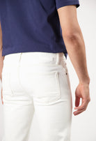 Sustainable MUD Jeans in dark denim, classic fit, viewed from the back, paired with a black t-shirt and white sneakers.