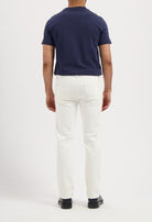 Sustainable MUD Jeans in dark indigo denim, paired with white sneakers, embodying ethical fashion.