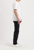 Sustainable MUD Jeans made from organic denim, featuring a relaxed fit in blue, paired with a classic white T-shirt.