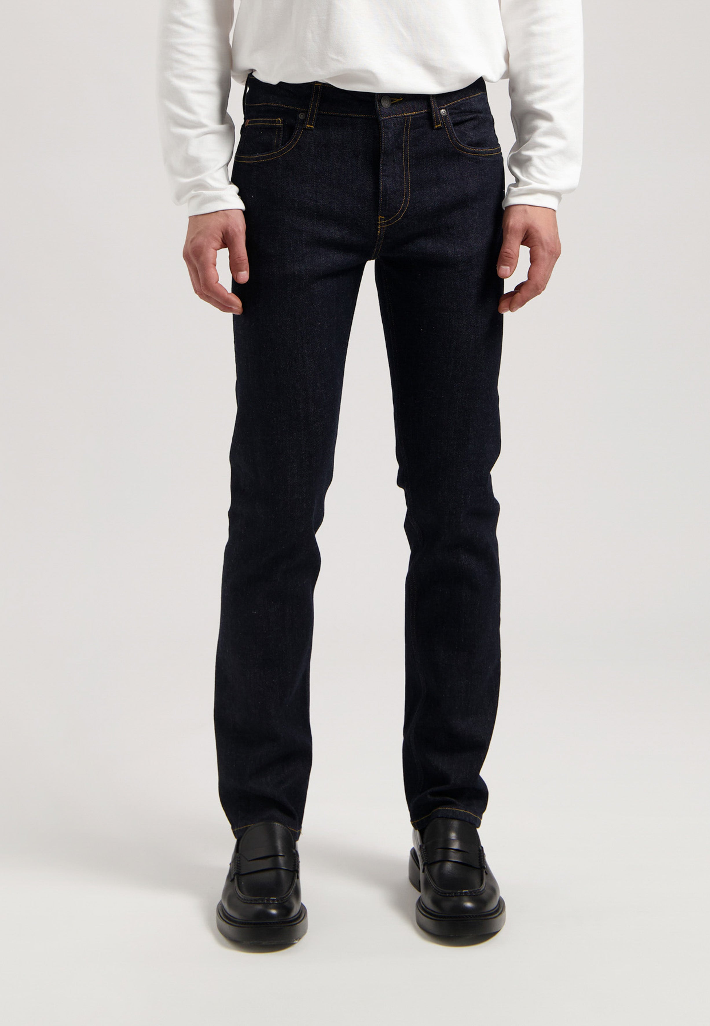 Sustainable MUD Jeans navy shorts made from organic cotton, paired with a white t-shirt, embodying ethical fashion.