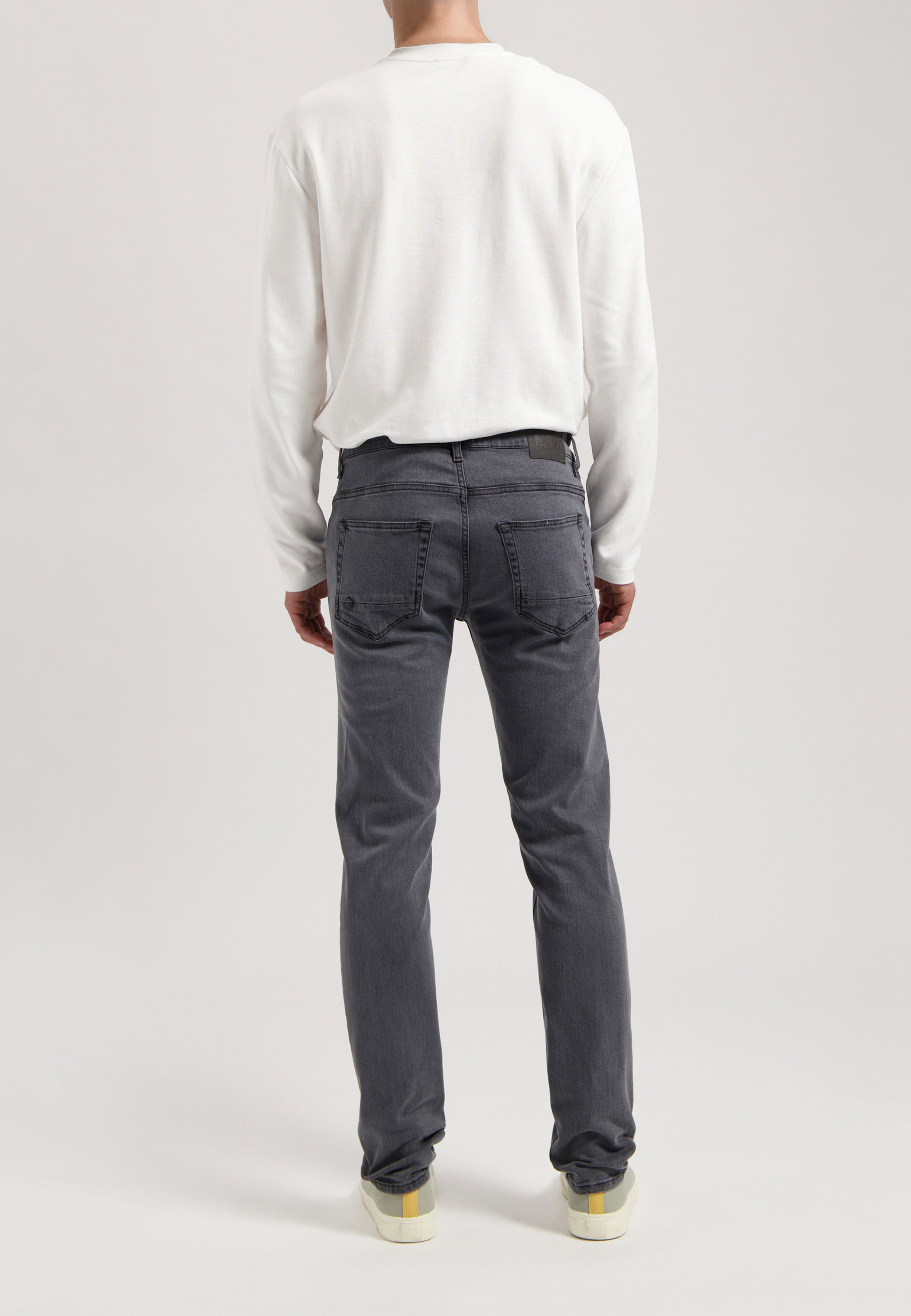 Sustainable MUD Jeans made from ethical materials, featuring classic blue denim, paired with a simple white tee.