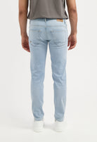 Sustainable MUD Jeans beige shorts made from eco-friendly materials, worn with gray shirt and white sneakers.