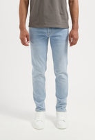 Sustainable MUD Jeans in beige, designed with ethical materials, paired with a gray t-shirt and white sneakers.