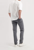 Sustainable MUD Jeans in gray denim, showcasing ethical fashion with comfortable fit, paired with a sleek black sweater.
