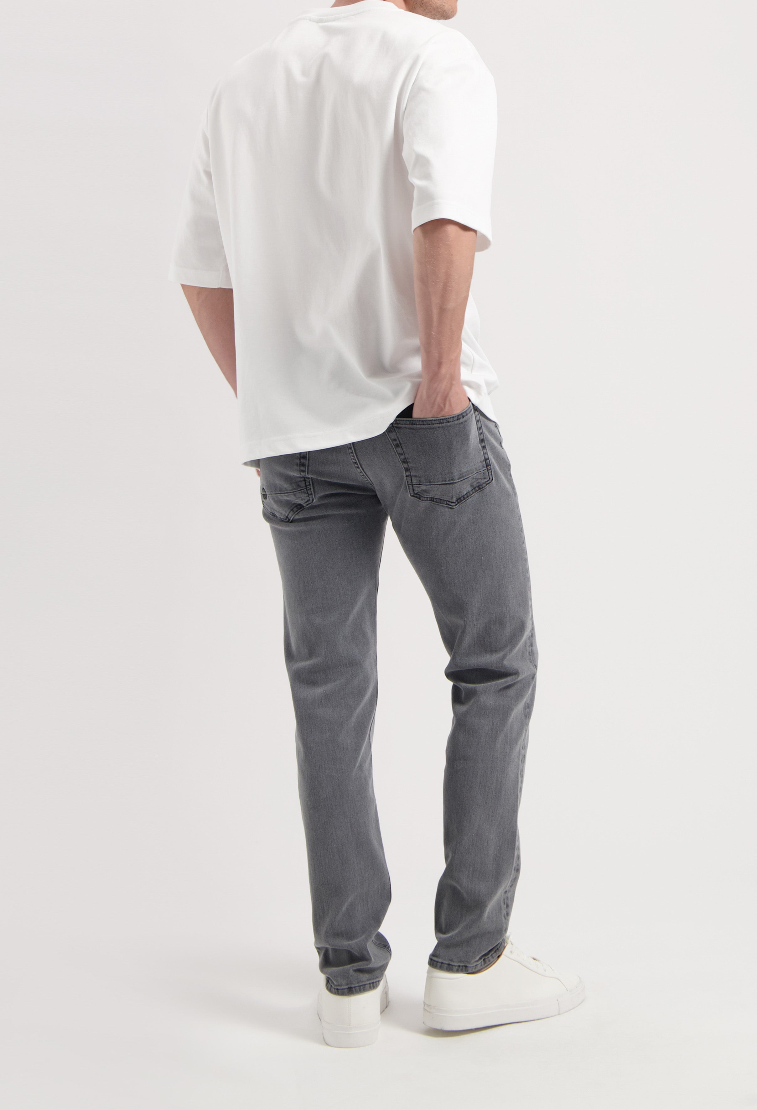 Sustainable MUD Jeans in gray denim, showcasing ethical fashion with comfortable fit, paired with a sleek black sweater.