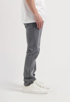 Sustainable MUD Jeans in gray denim, showcasing ethical design with a sleek fit, paired with a black top.
