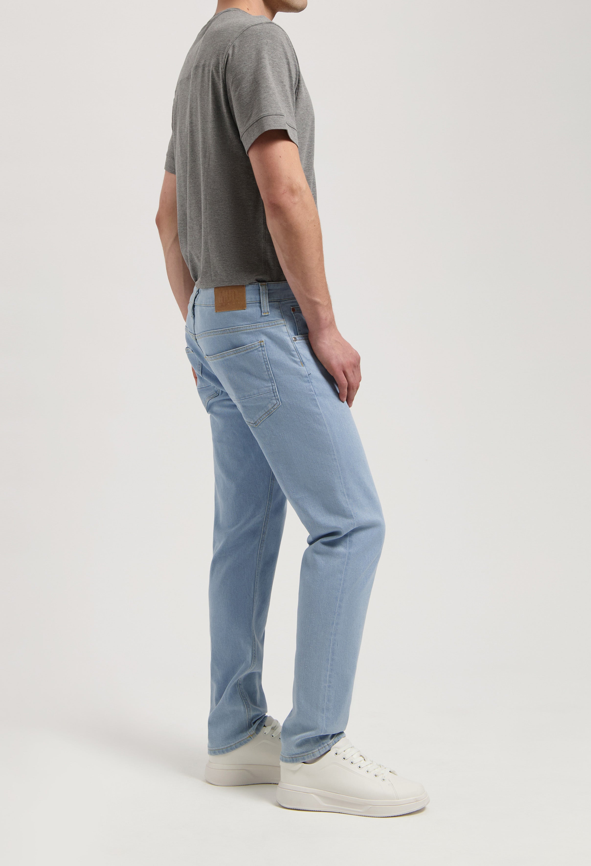 Model wearing Dunn Low Tapered jeans in light vintage, made from sustainable organic cotton and TENCEL™, offering a tapered fit.