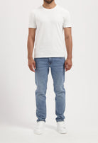 Sustainable MUD Jeans beige shorts, crafted for ethical fashion, paired with casual gray shirt for modern style.