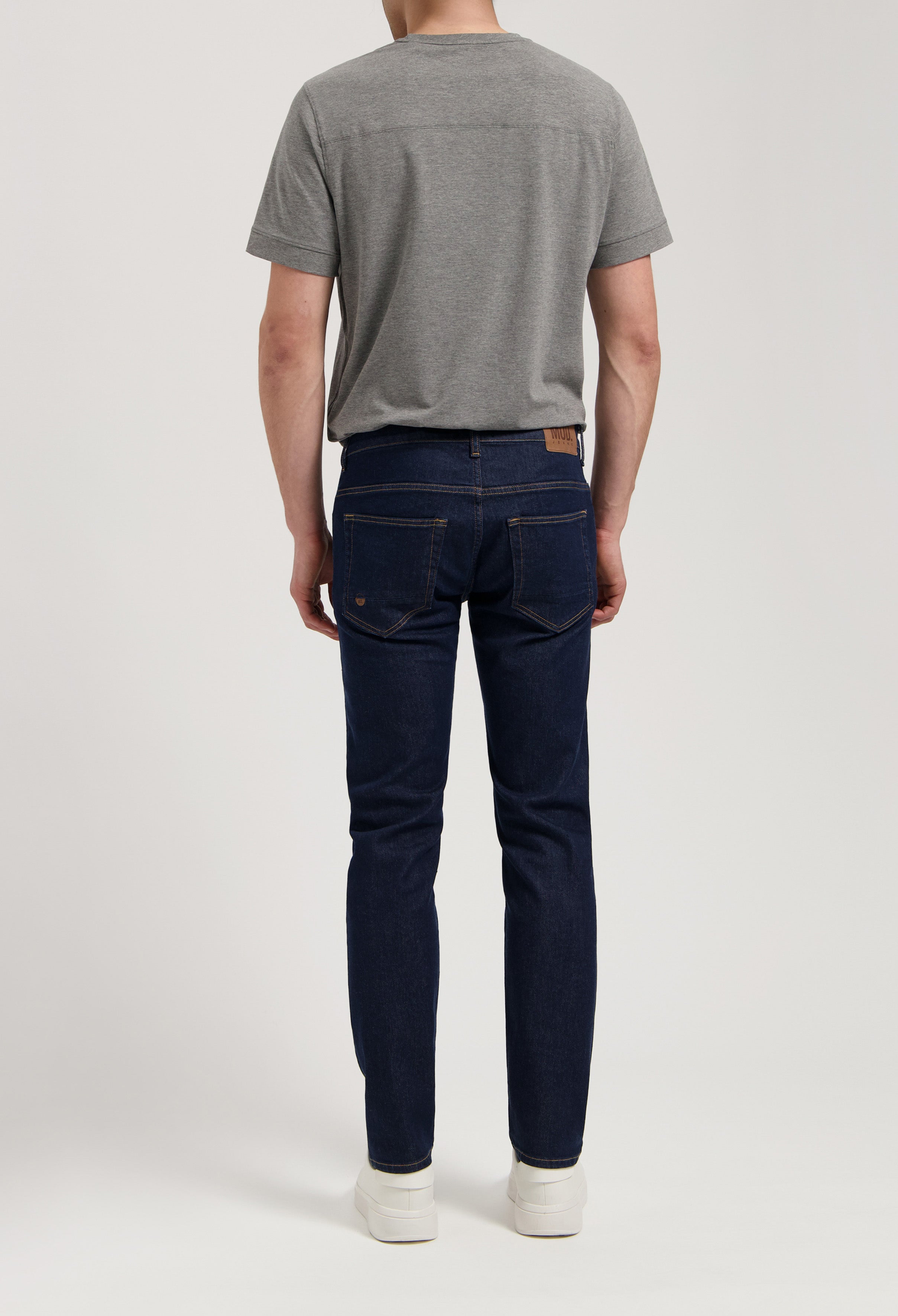 Model wearing Dunn Low Tapered jeans in strong blue, made from sustainable organic cotton and TENCEL™, offering a tapered fit.