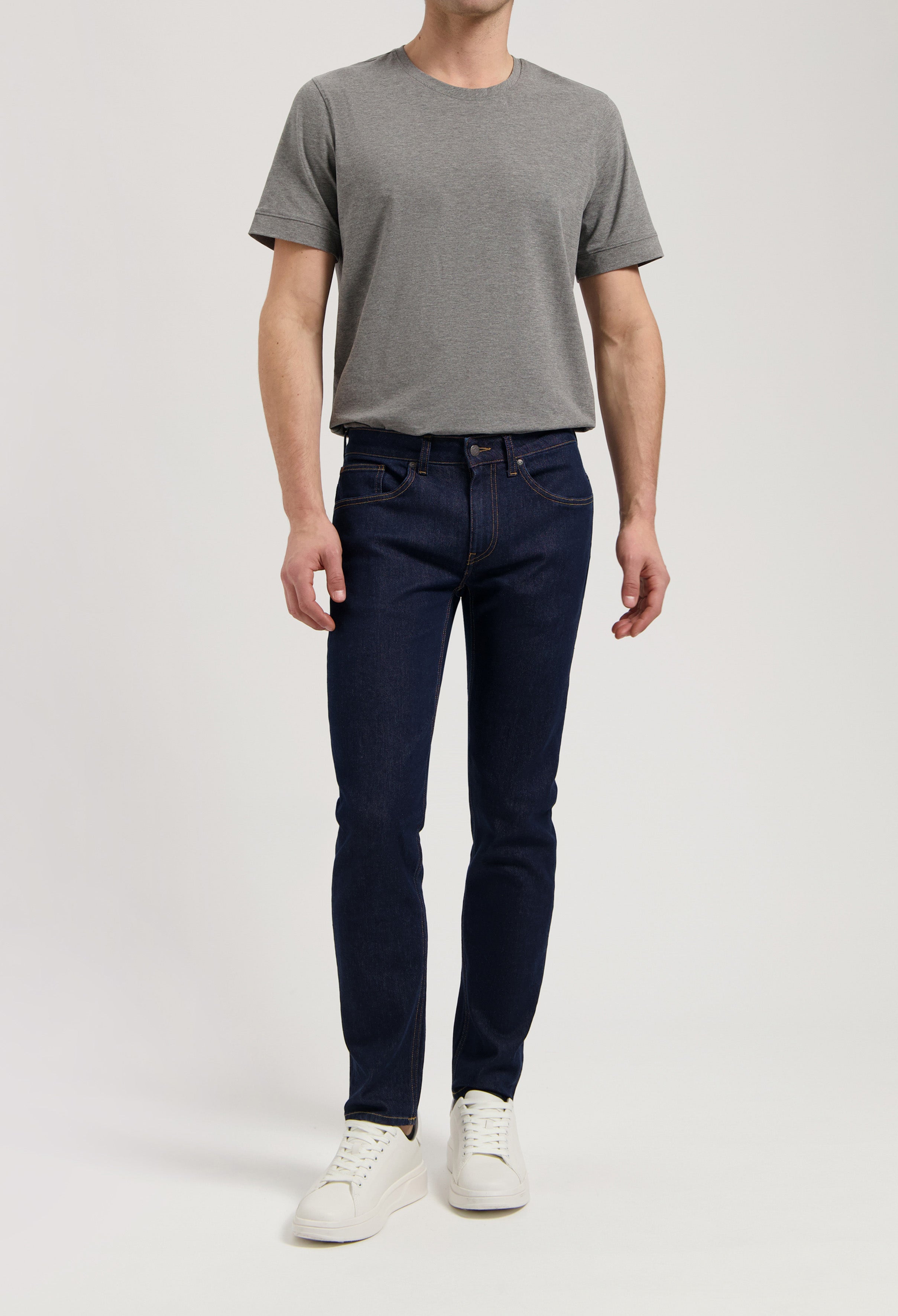 Model wearing Dunn Low Tapered jeans in strong blue, made from sustainable organic cotton and TENCEL™, offering a tapered fit.