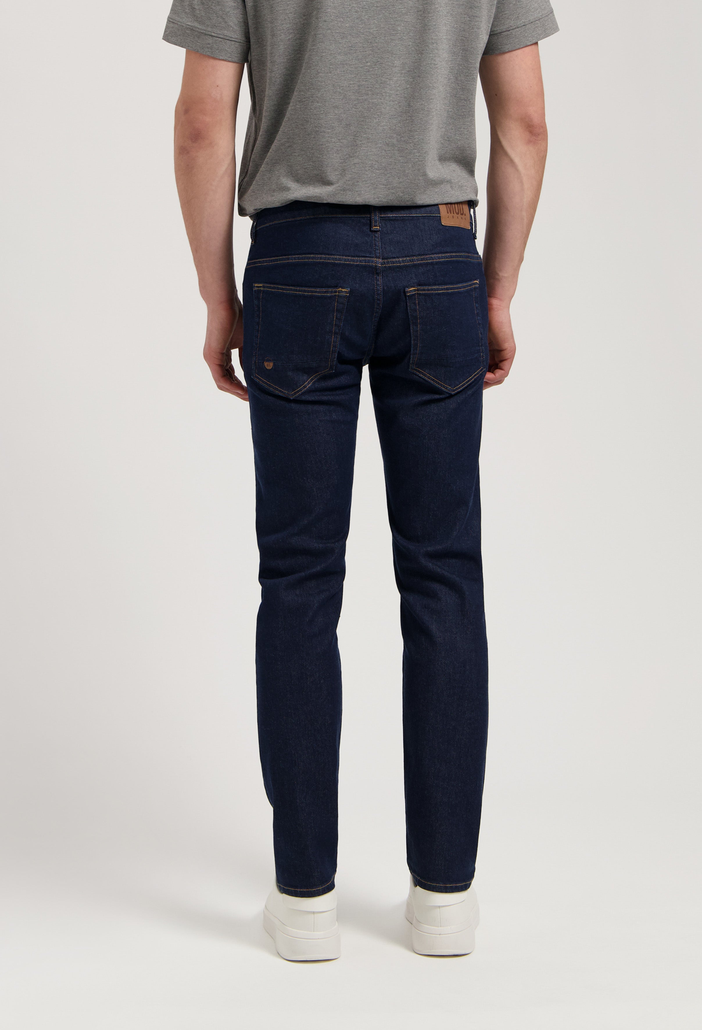 Model wearing Dunn Low Tapered jeans in strong blue, made from sustainable organic cotton and TENCEL™, offering a tapered fit.