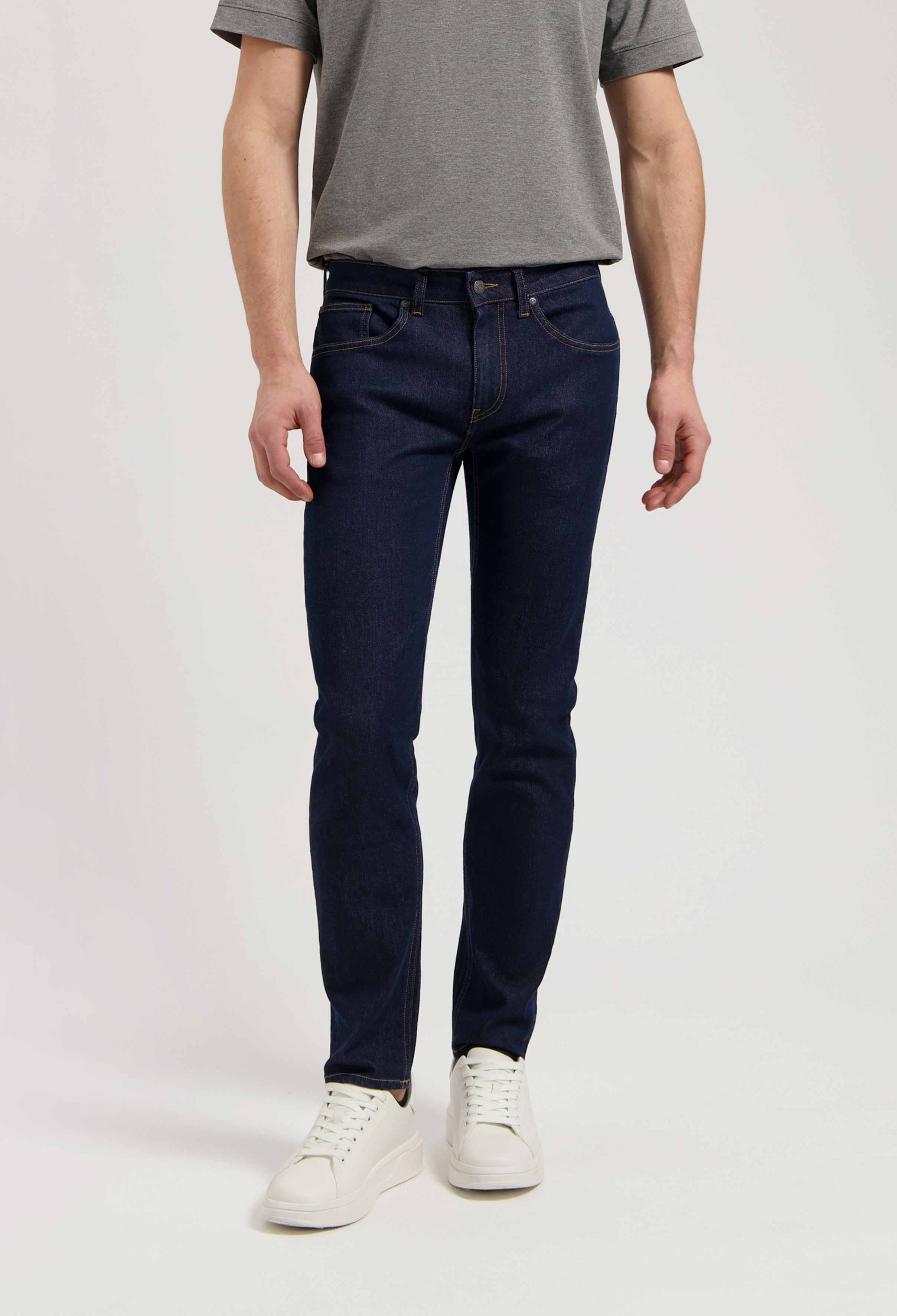 Model wearing Dunn Low Tapered jeans in strong blue, made from sustainable organic cotton and TENCEL™, offering a tapered fit.