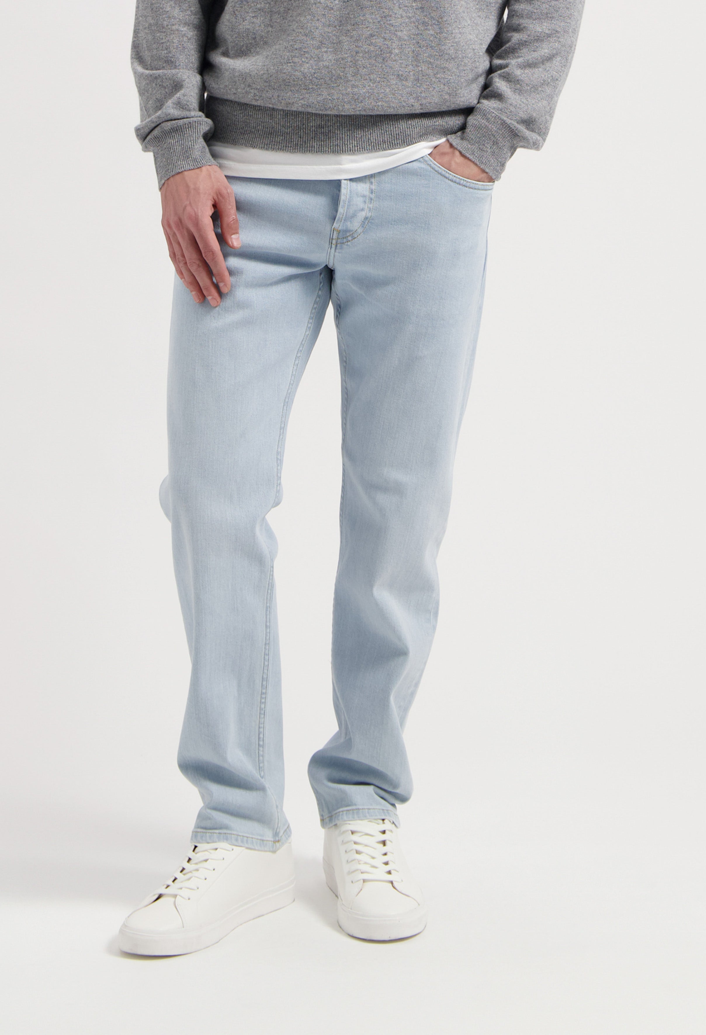 Sustainable MUD Jeans in dark gray denim with a modern fit, showcasing ethical fashion paired with casual sneakers.