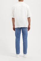 Sustainable MUD Jeans in light blue denim, crafted ethically from organic cotton, paired with a classic black t-shirt.