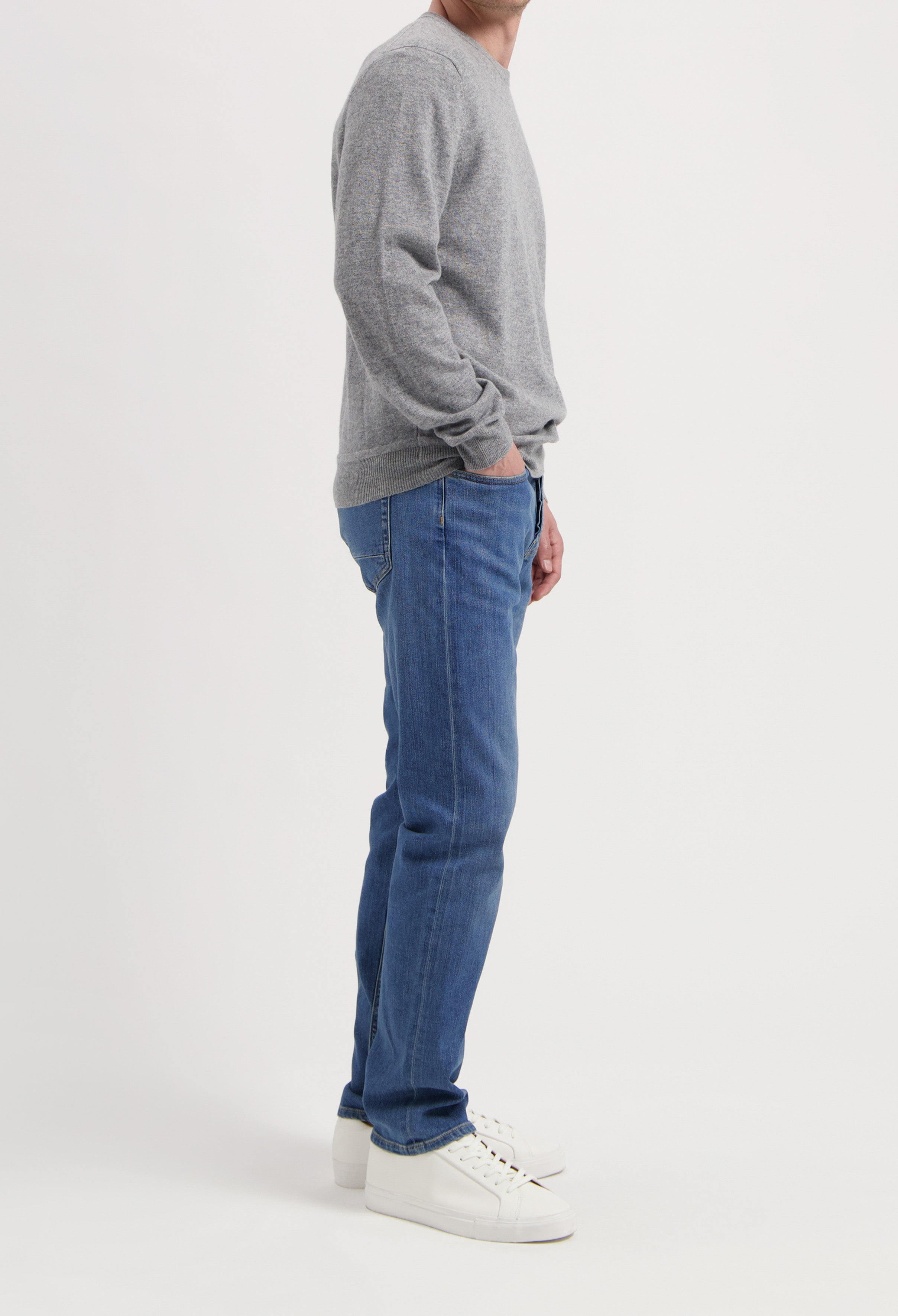 Sustainable MUD Jeans in classic blue denim, paired with a dark blue jacket, embodying ethical fashion style.