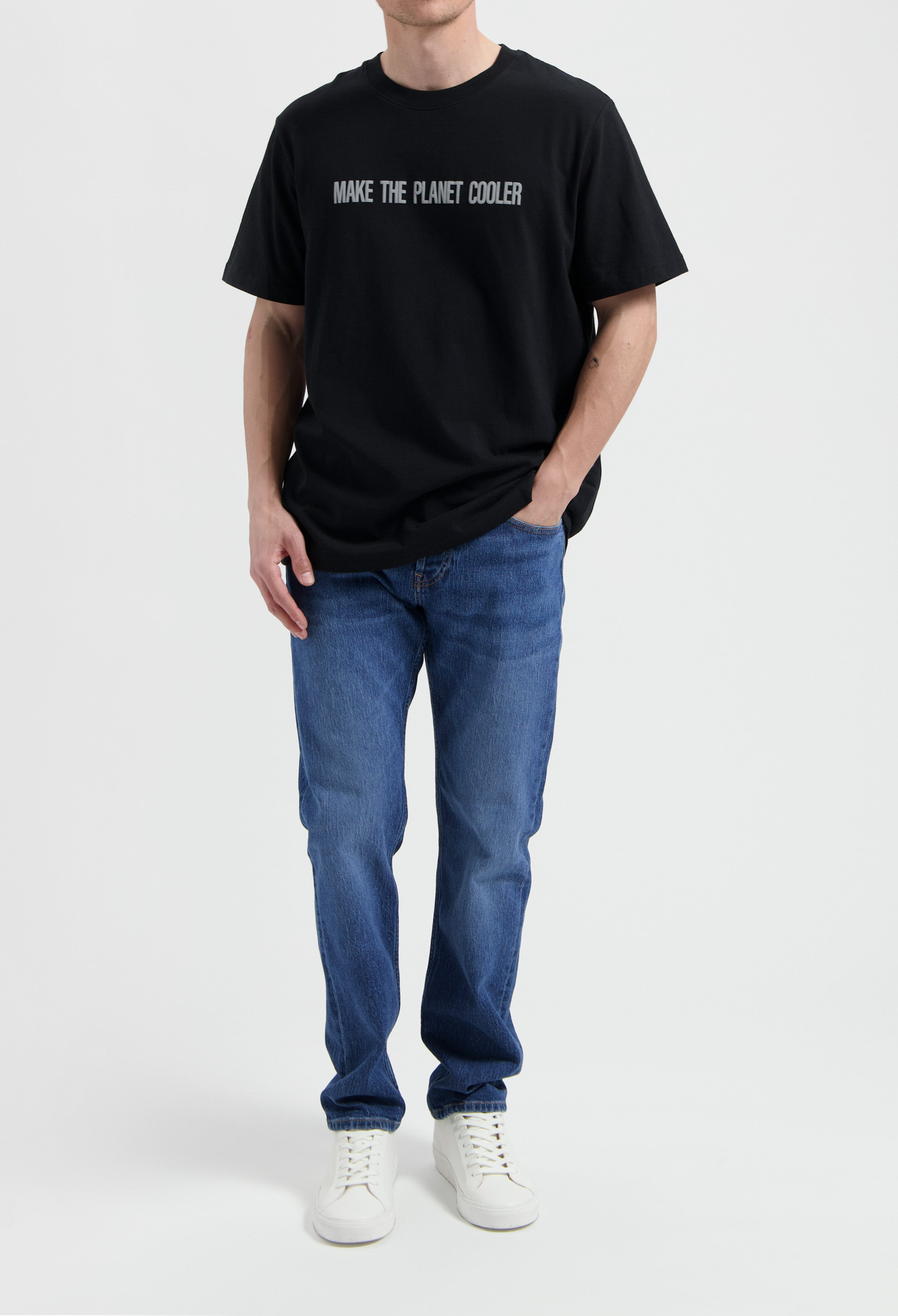 Sustainable MUD Jeans in dark denim, emphasizing ethical fashion, paired with a white t-shirt for a classic look.