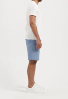 Sustainable MUD Jeans in deep blue denim, crafted from organic cotton, paired with a light gray sweater for an eco-friendly look.